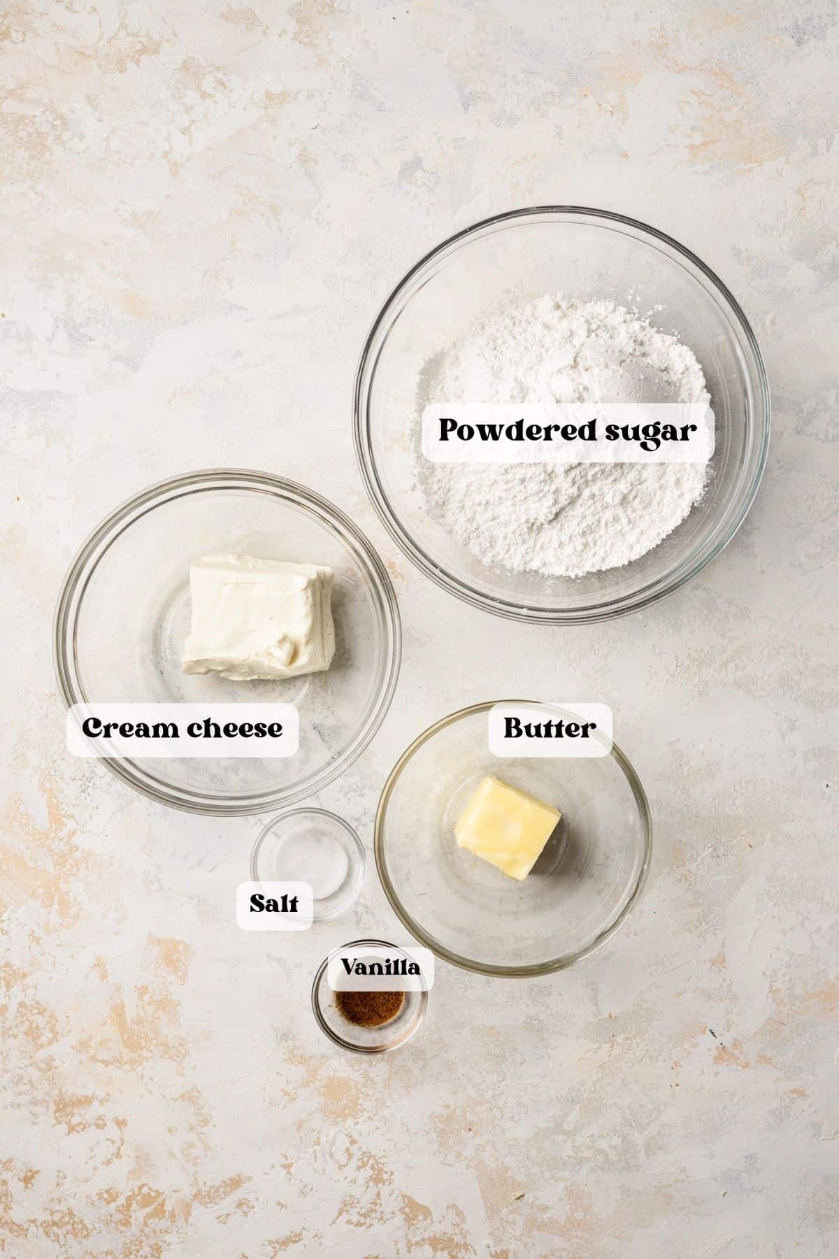 Ingredients for cream cheese frosting on a white surface.