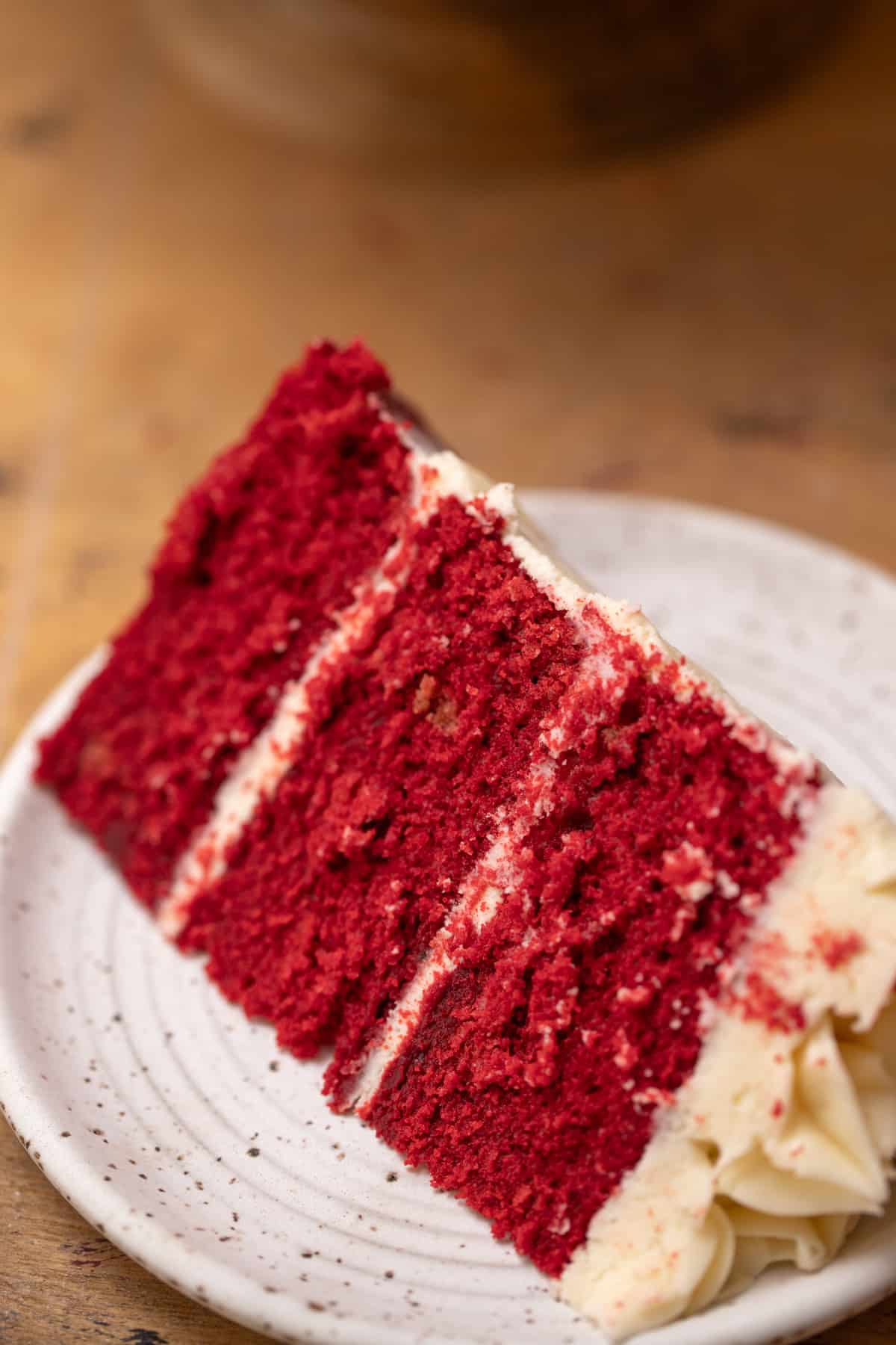 A slice of red velvet cake on a white plate.