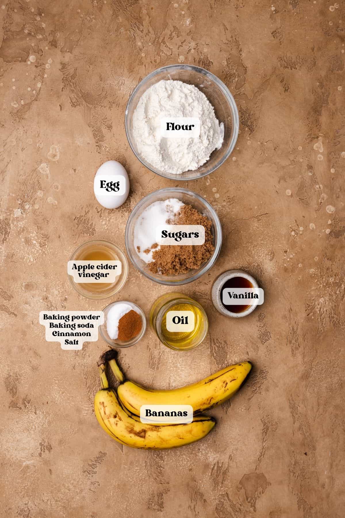 Ingredients to make banana bars on a tan surface.