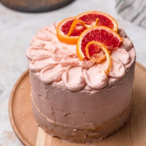 Blood orange cake on a wood cake stand.