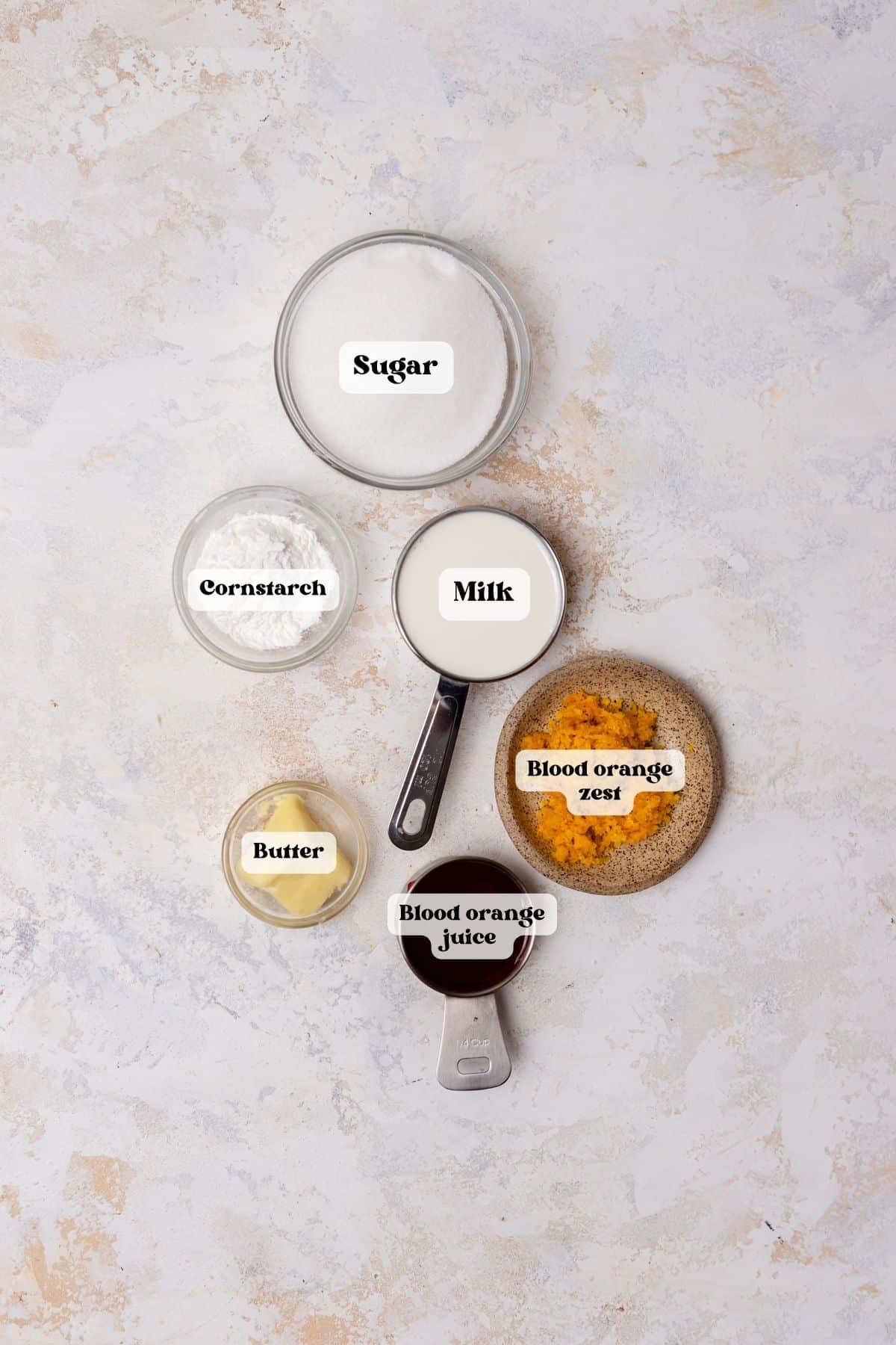 Ingredients to make blood orange curd on a white surface.