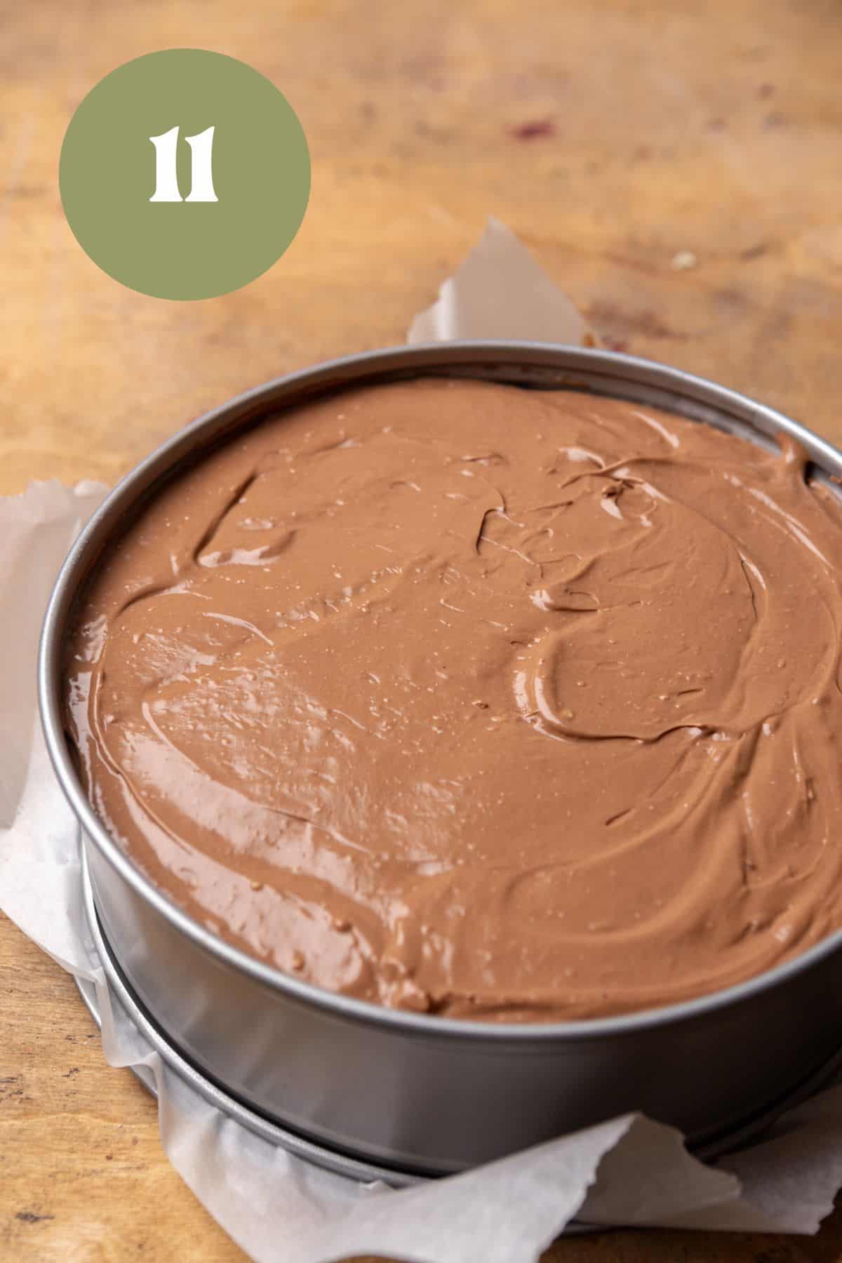 Unbaked cosmic brownie cheesecake in a springform pan.