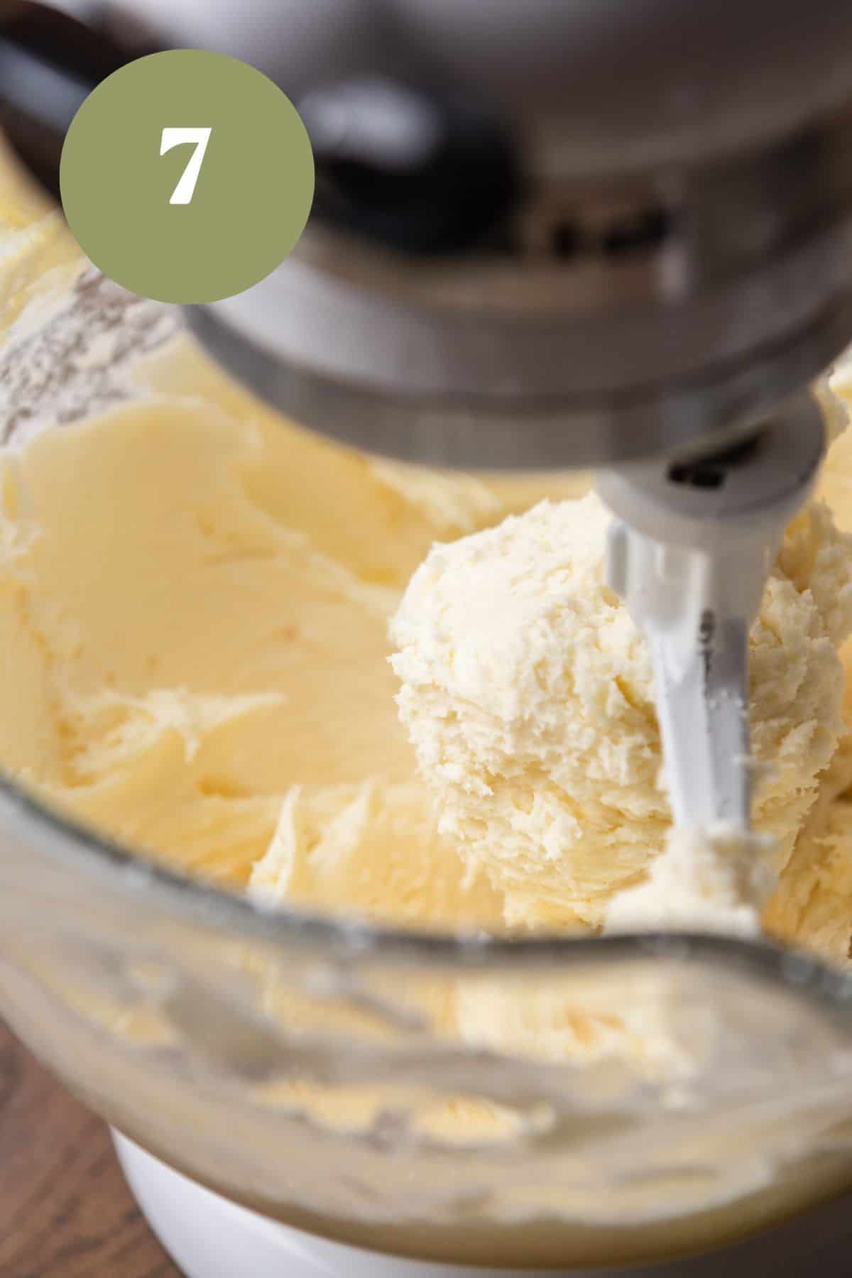 Cream cheese frosting being mixed in the bowl of a stand mixer.
