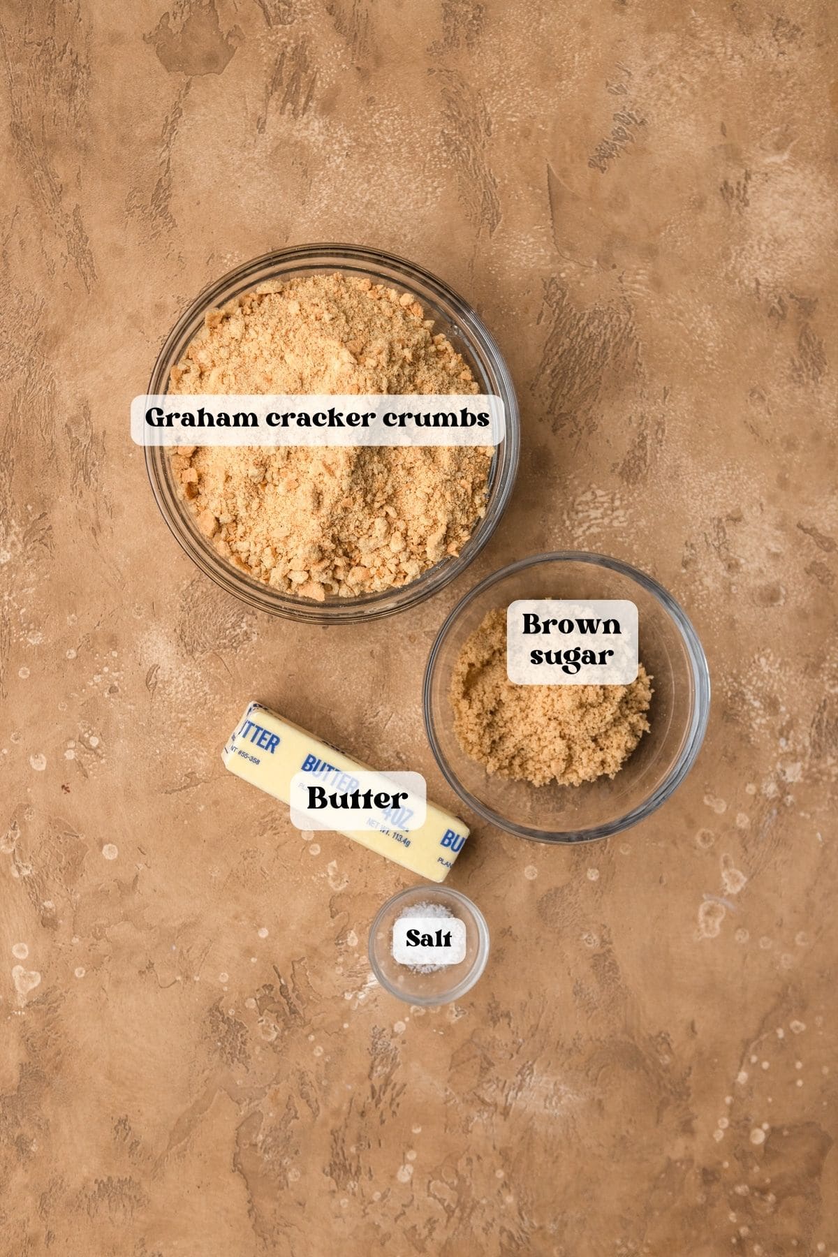 Ingredients to make graham cracker crust on a tan surface.