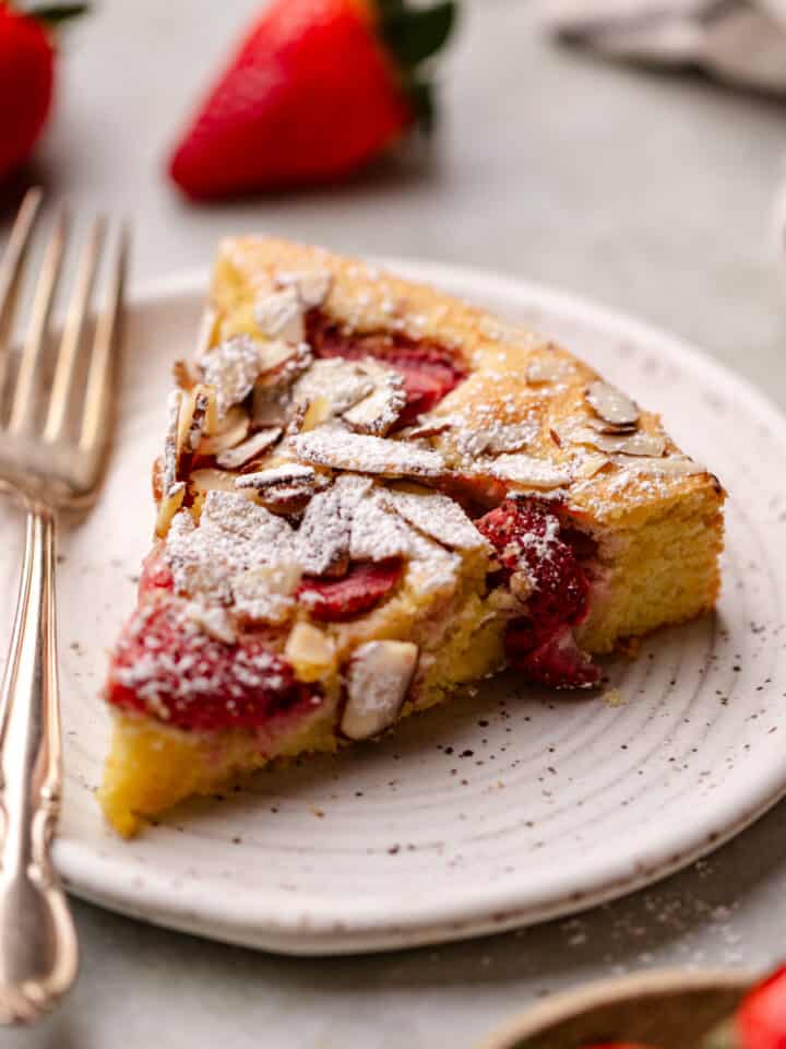 A slice of strawberry almond flour cake on a white plate.