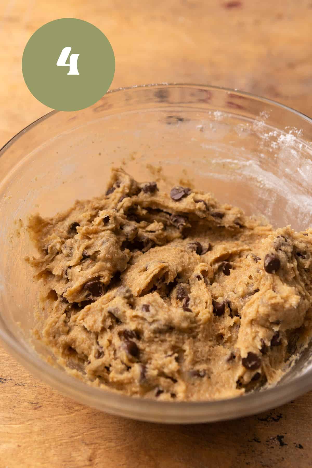 Chocolate chip cookie dough in a glass bowl.