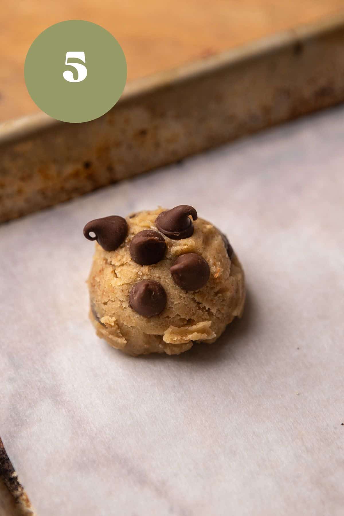 A cookie dough ball on baking sheet.