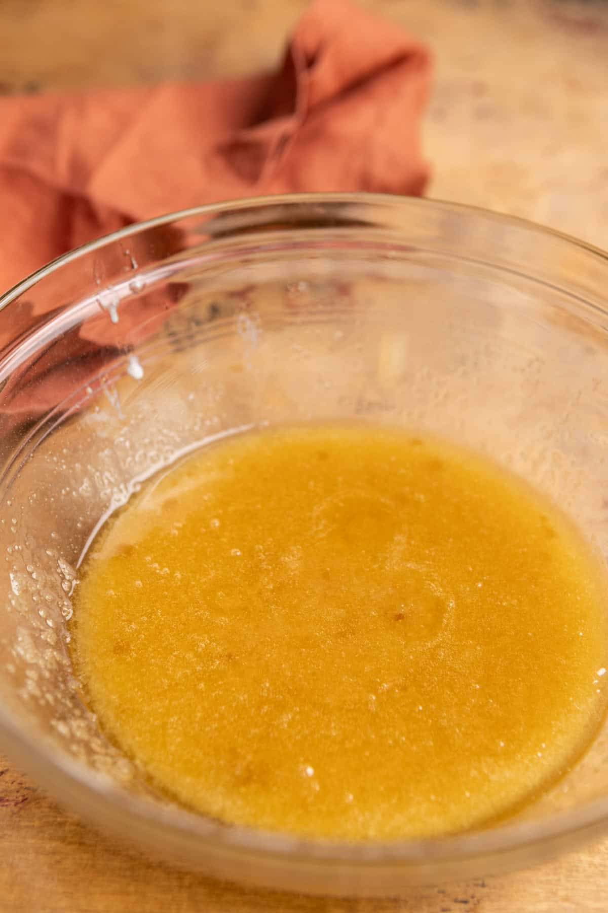 Melted butter and sugar in a glass bowl.