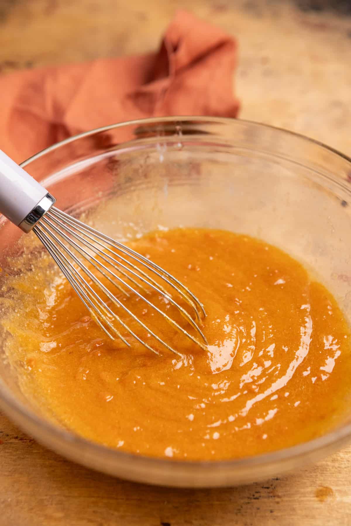 Melted butter and sugar whisked with pumpkin in a bowl.