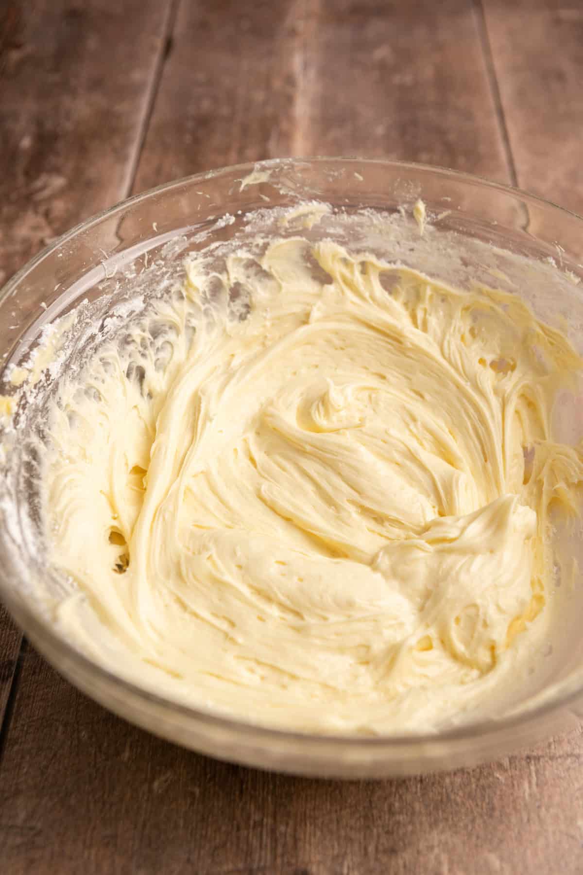 Cream cheese frosting in a glass bowl.