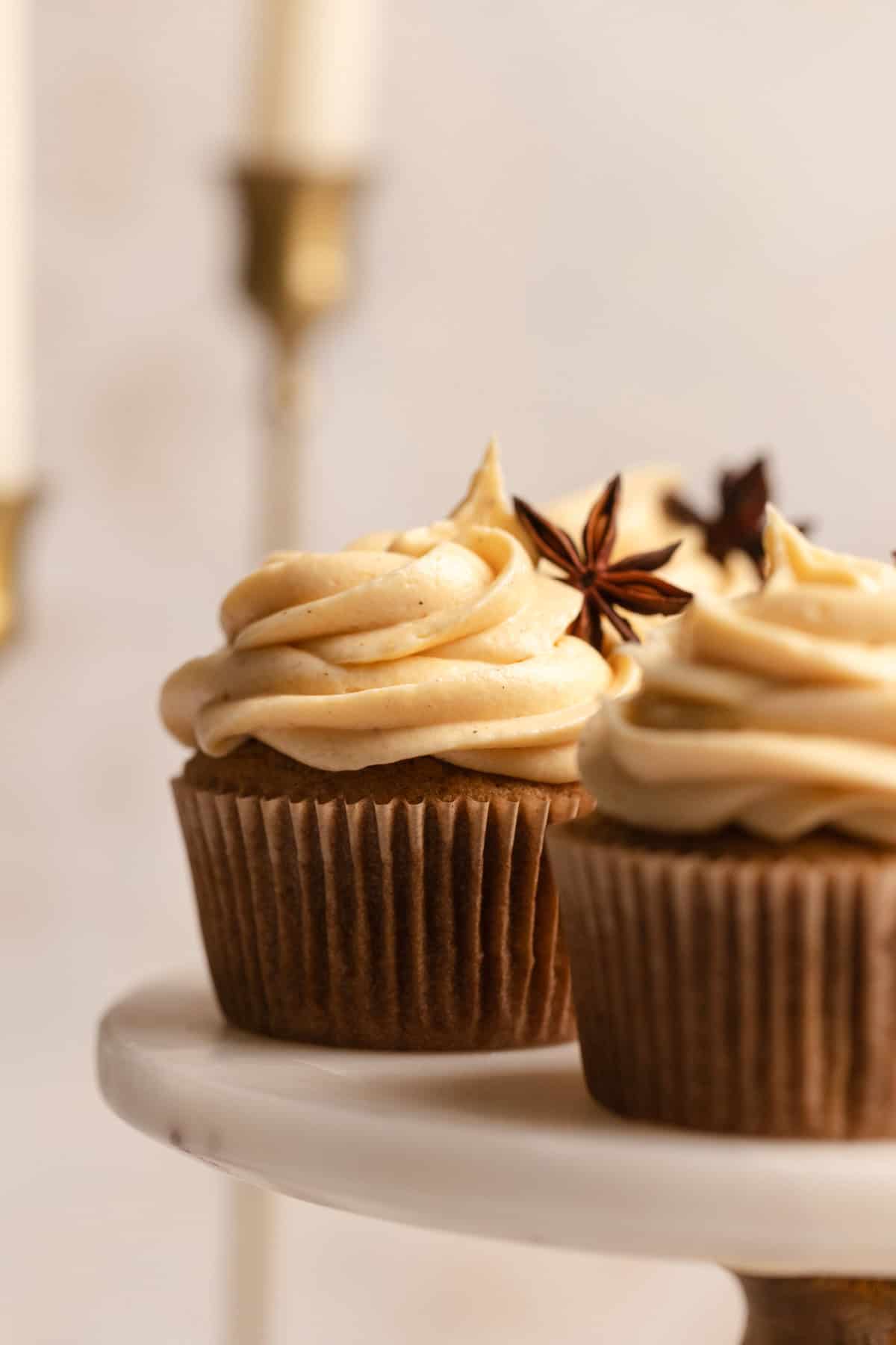 A close up of pumpkin spice cupcakes garnished with star anise.