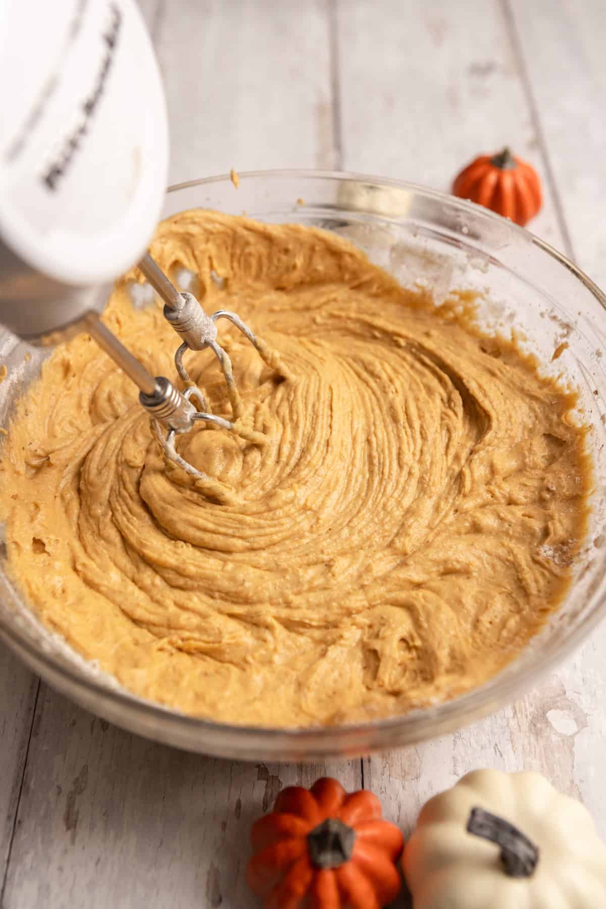 Cupcake batter in a mixing bowl with a mixer.