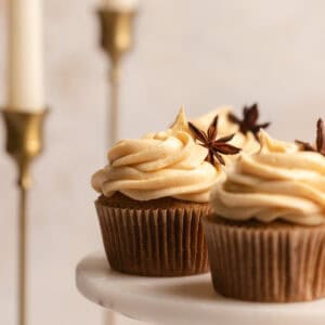 Pumpkin spice cupcakes on a cake stand.