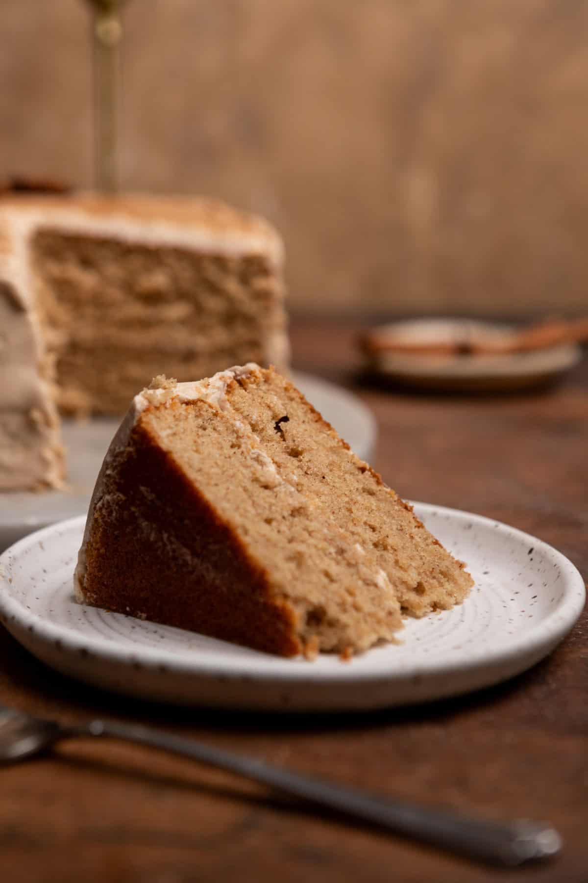 A slice of chai spice cake on a white plate.