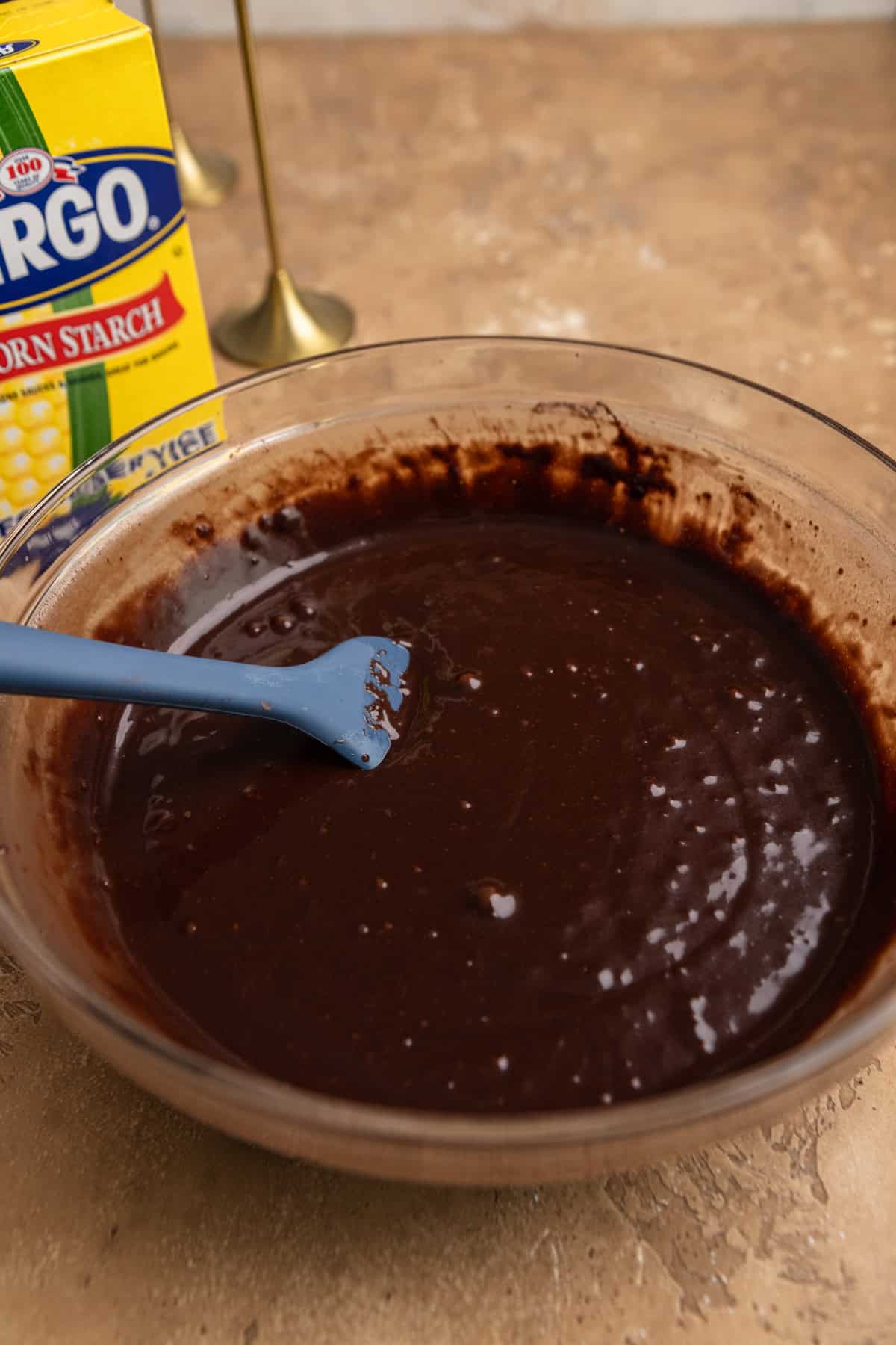 Chocolate cupcake batter in a bowl with a rubber spatula.