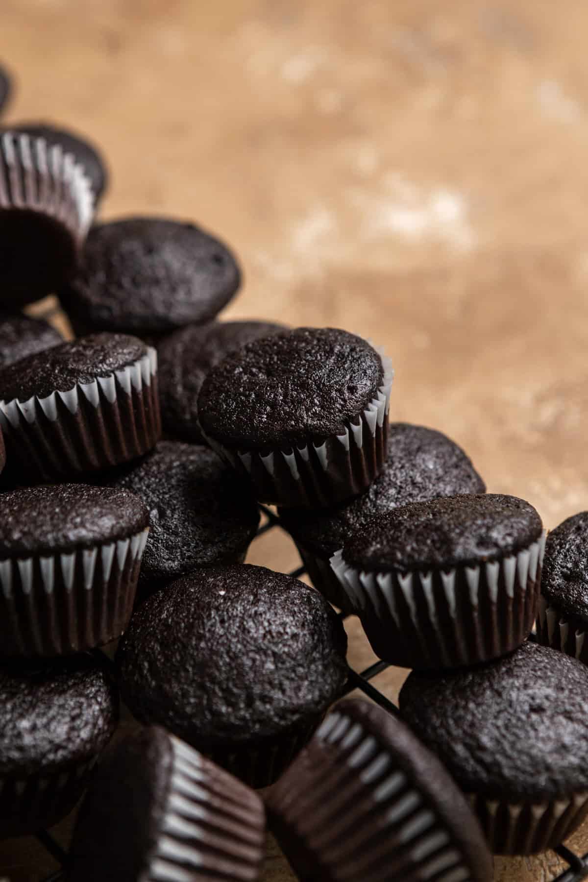 Unfrosted mini cupcakes on a wire cooling rack.