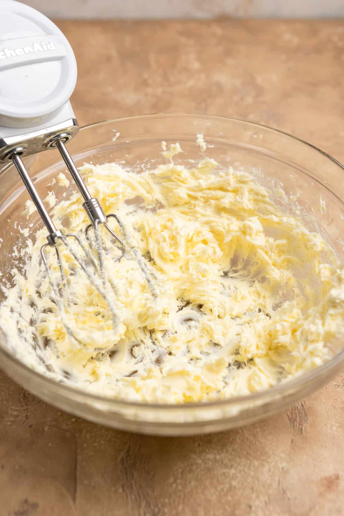 Butter creamed in a large bowl with a mixer.