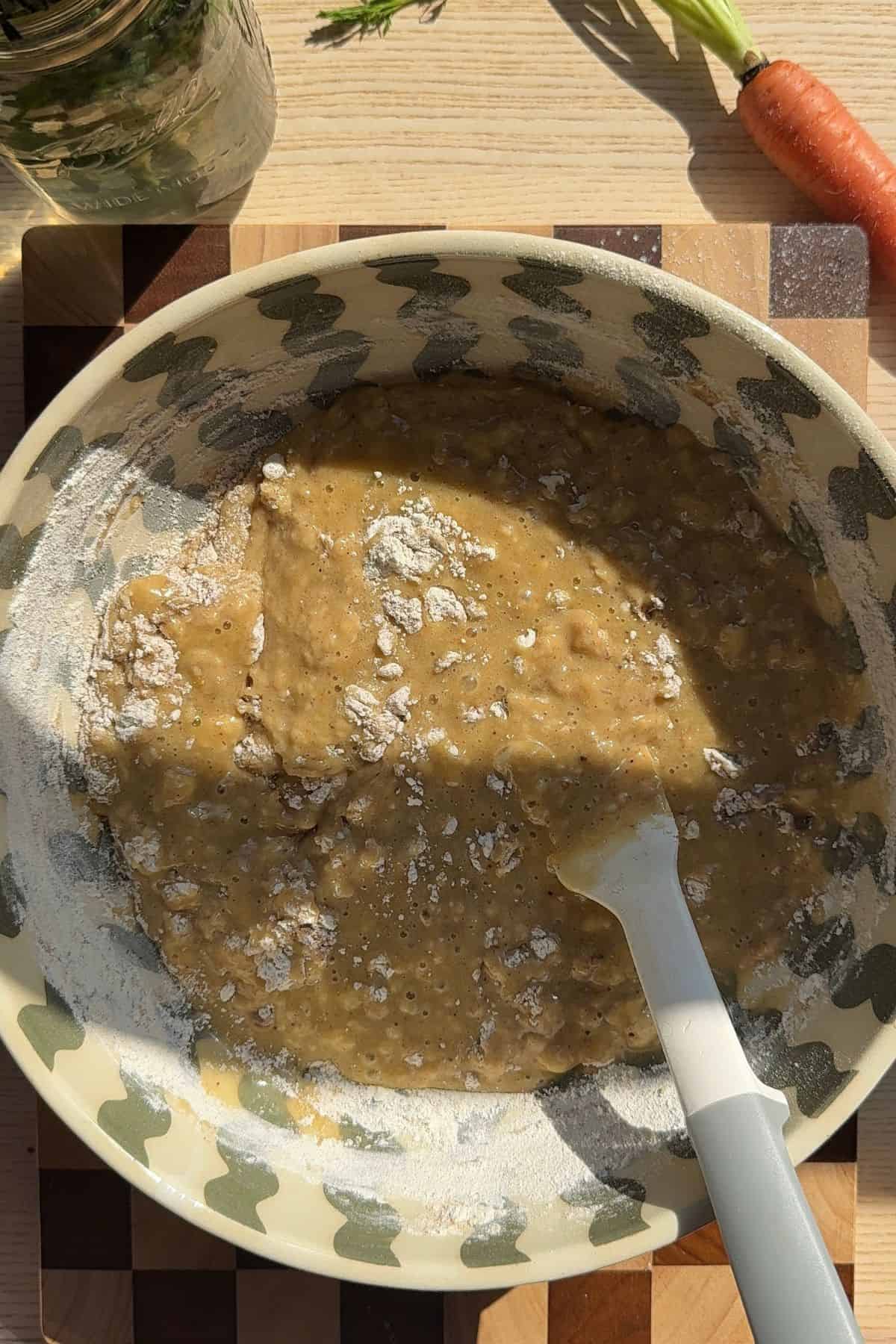 Muffin batter in a bowl with dry streaks remaining.
