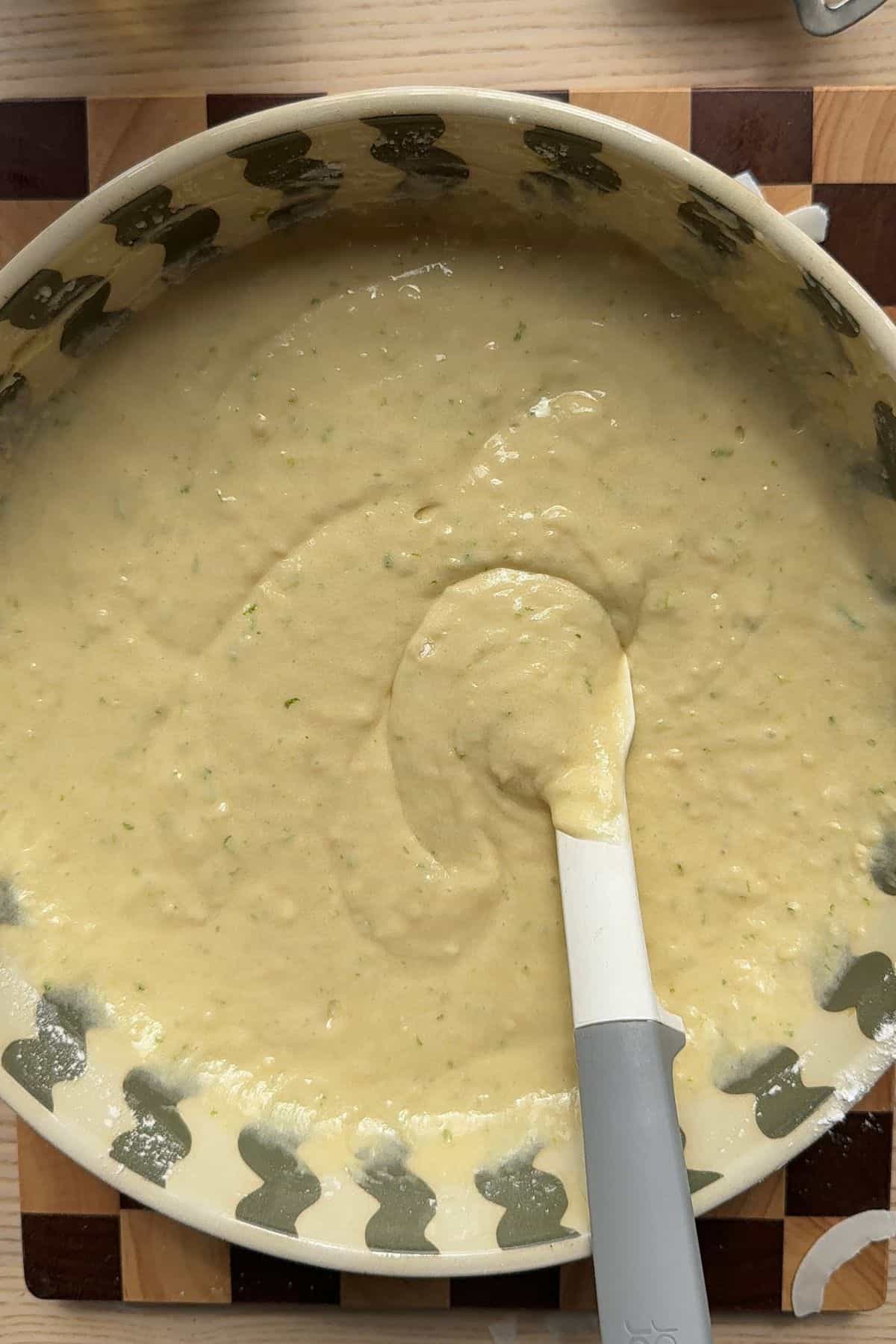 Cake batter in a large bowl with a rubber spatula.