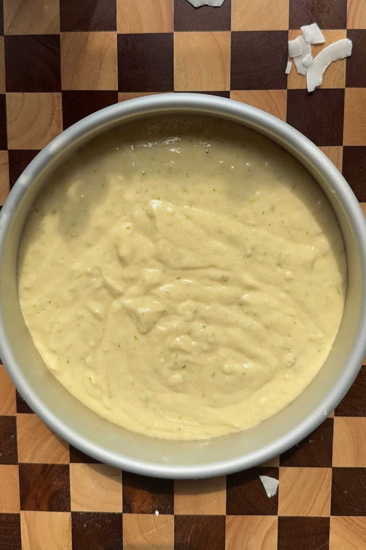 Unbaked cake batter in a round cake pan.