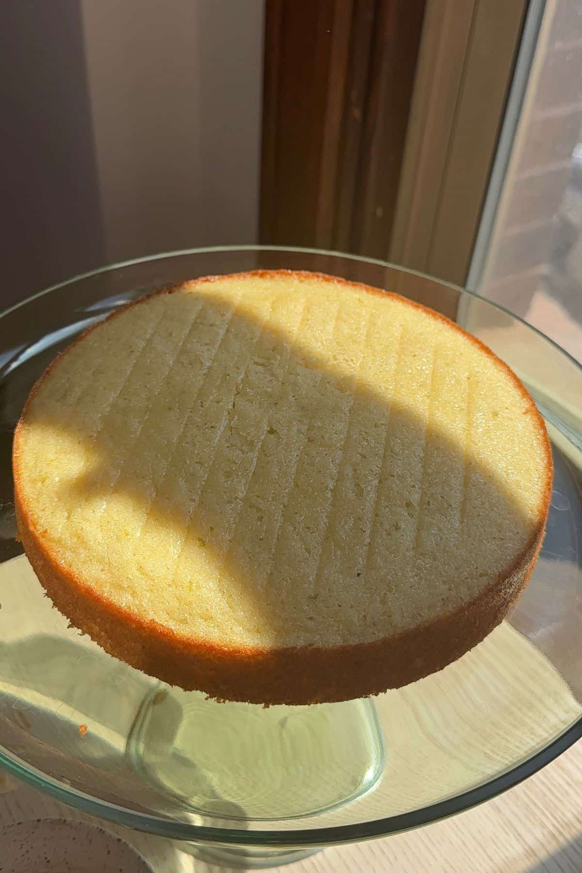 A layer of cake on a green glass cake stand.