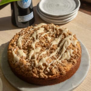 A coffee cake with cream cheese Irish cream icing on a round stone platter.