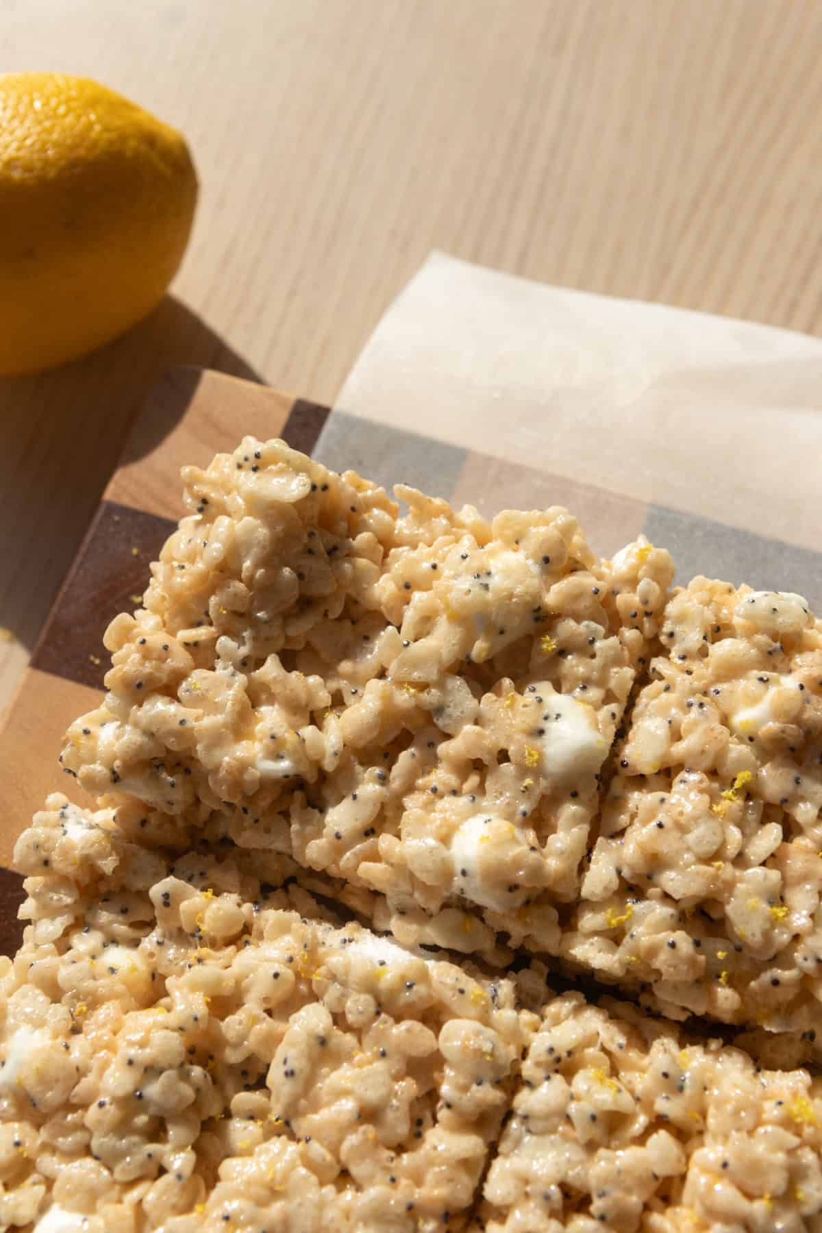 Lemon poppy seed Rice Krispie treats on a cutting board.
