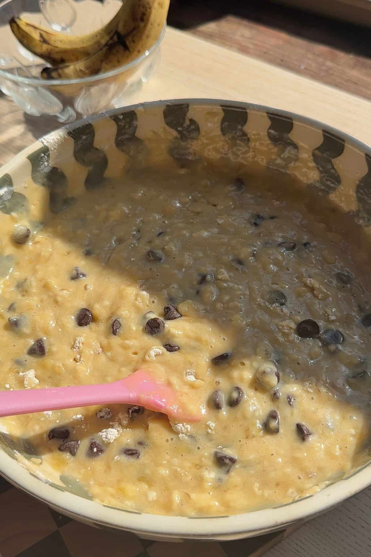 Banana bread muffin batter in a bowl with chocolate chips.