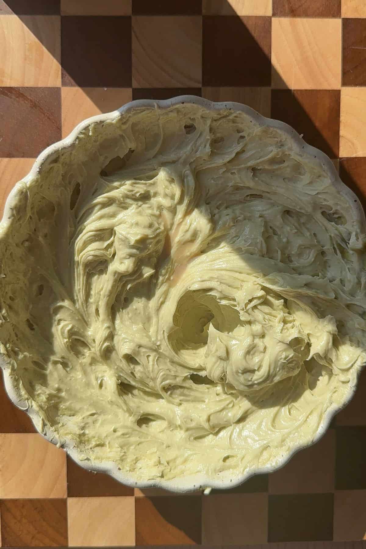Pistachio cream cheese frosting in a white bowl.