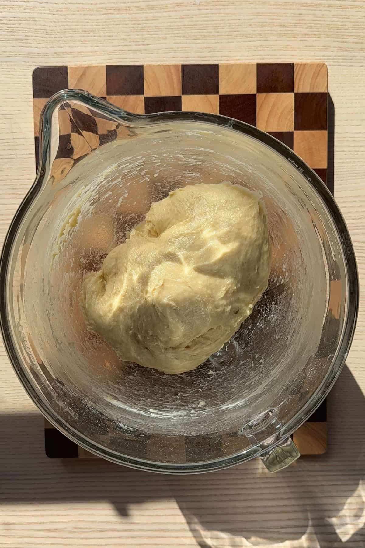 A dough ball in a glass bowl.