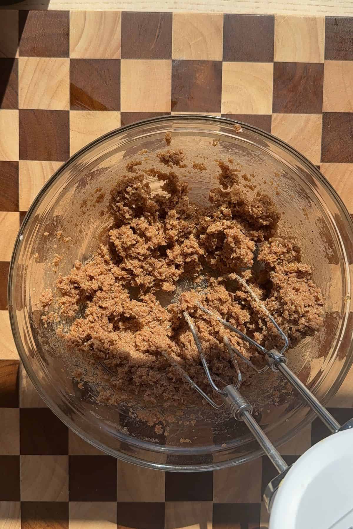 Butter, brown sugar, and cinnamon in a bowl with a hand mixer.
