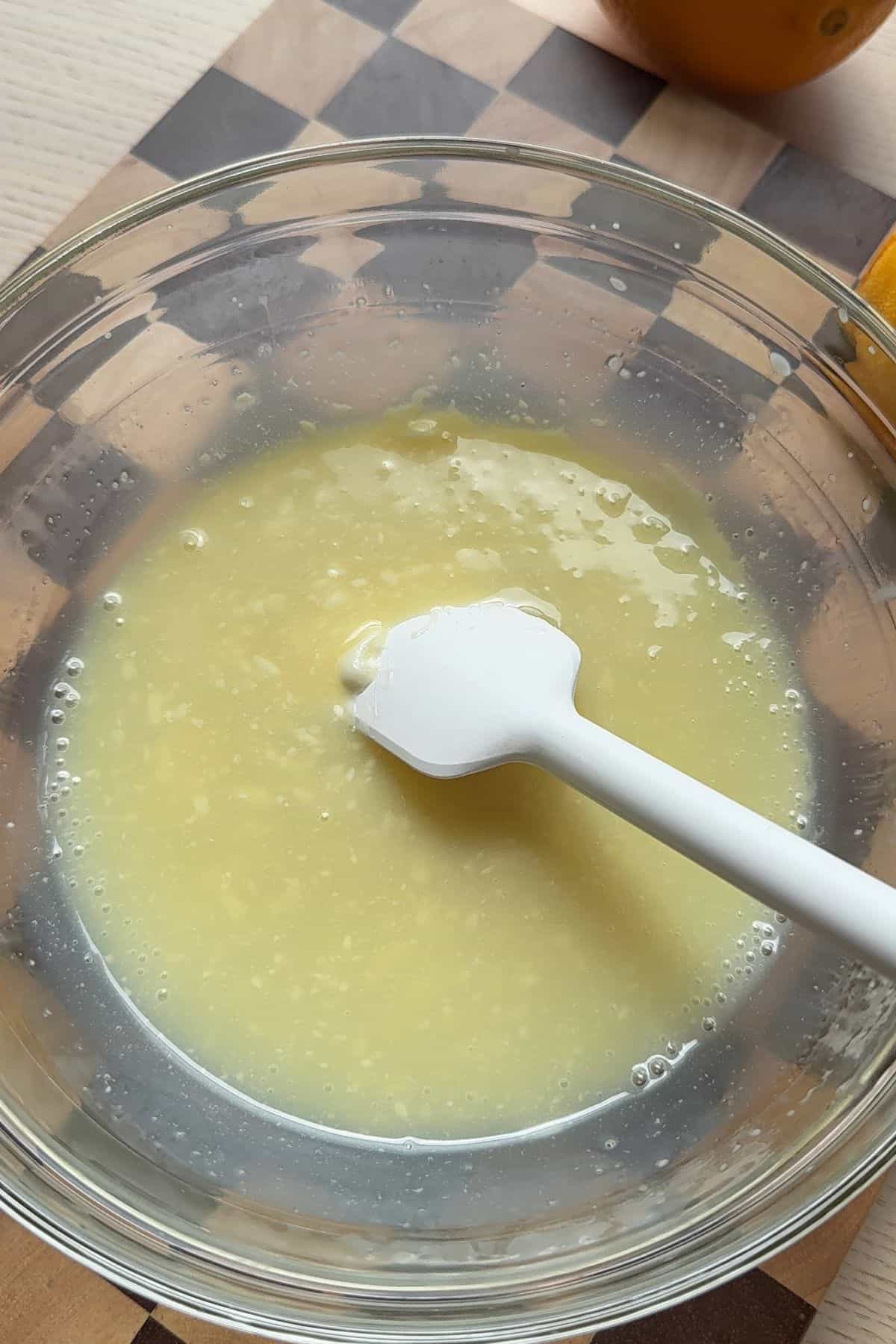 Melted white chocolate and cream in a bowl.