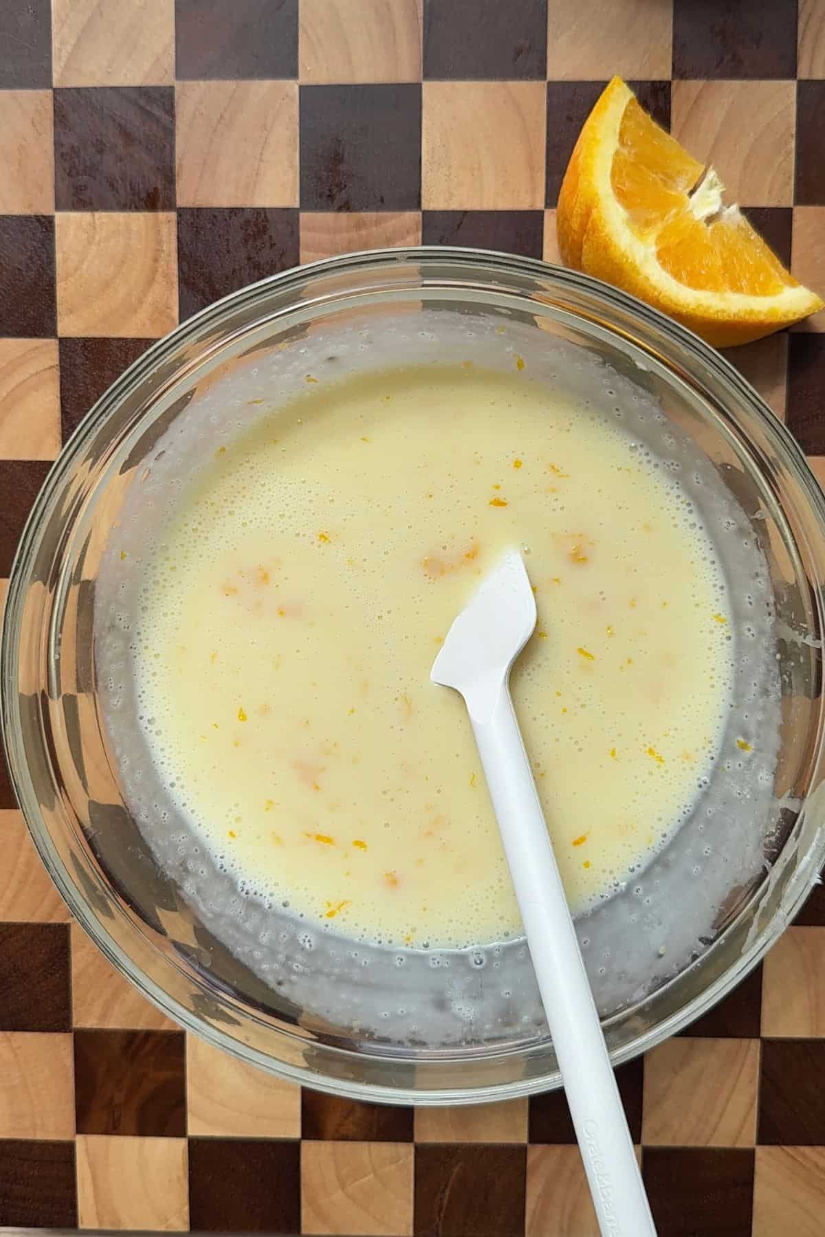 Heavy cream, white chocolate, orange juice, and zest combined in a large bowl.