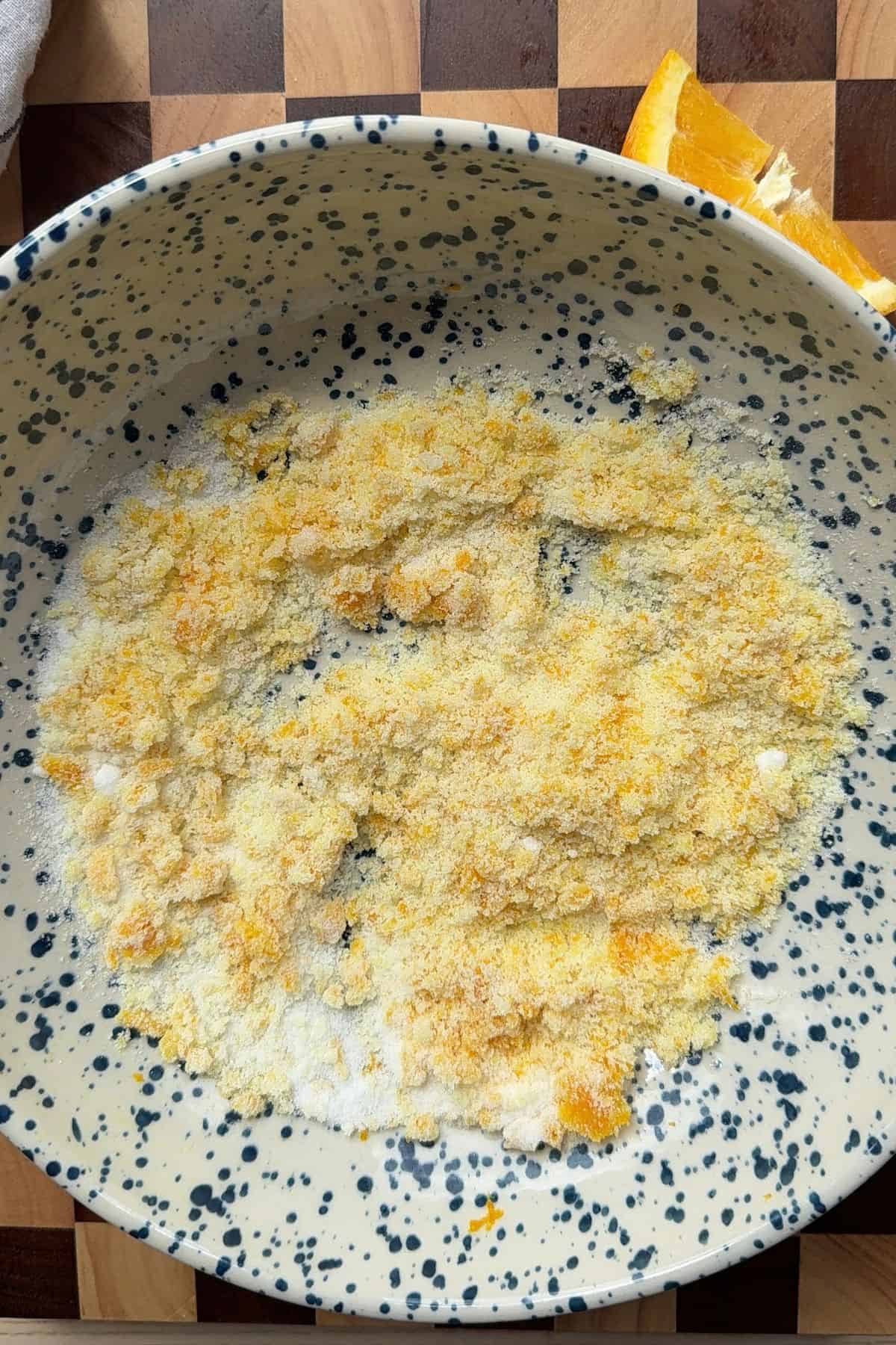 Sugar and orange zest in a bowl.