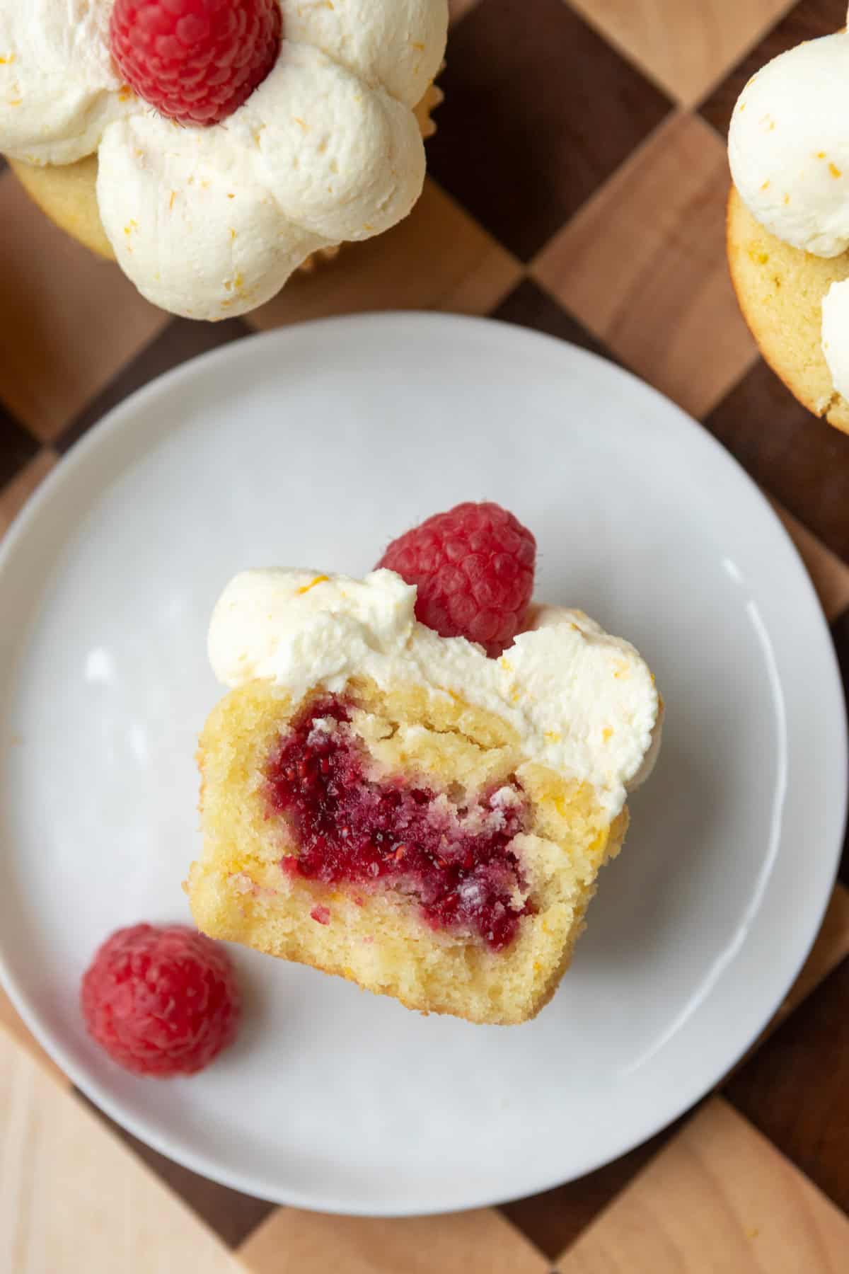 A raspberry orange cupcake cut open to show raspberry filling.