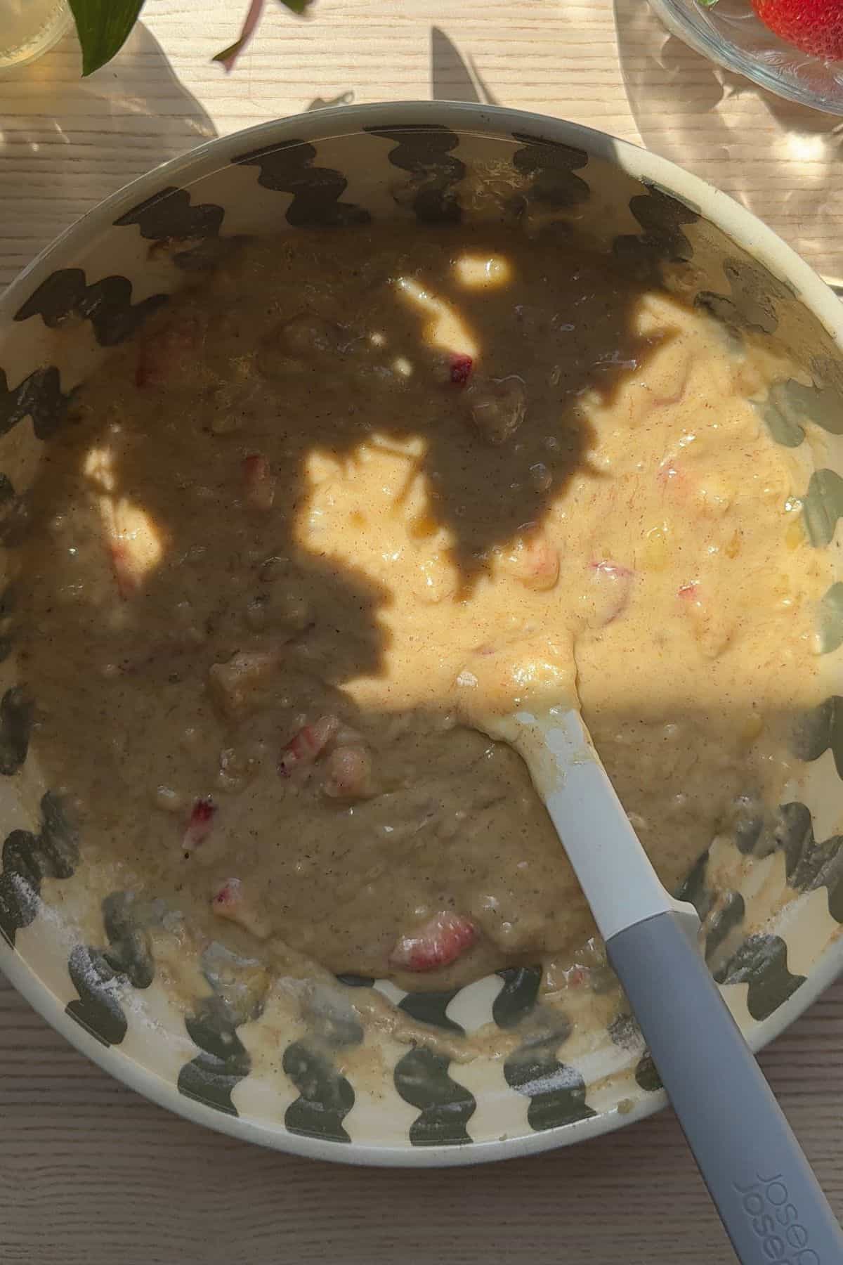 Strawberry banana bread batter in a large bowl with a spatula.