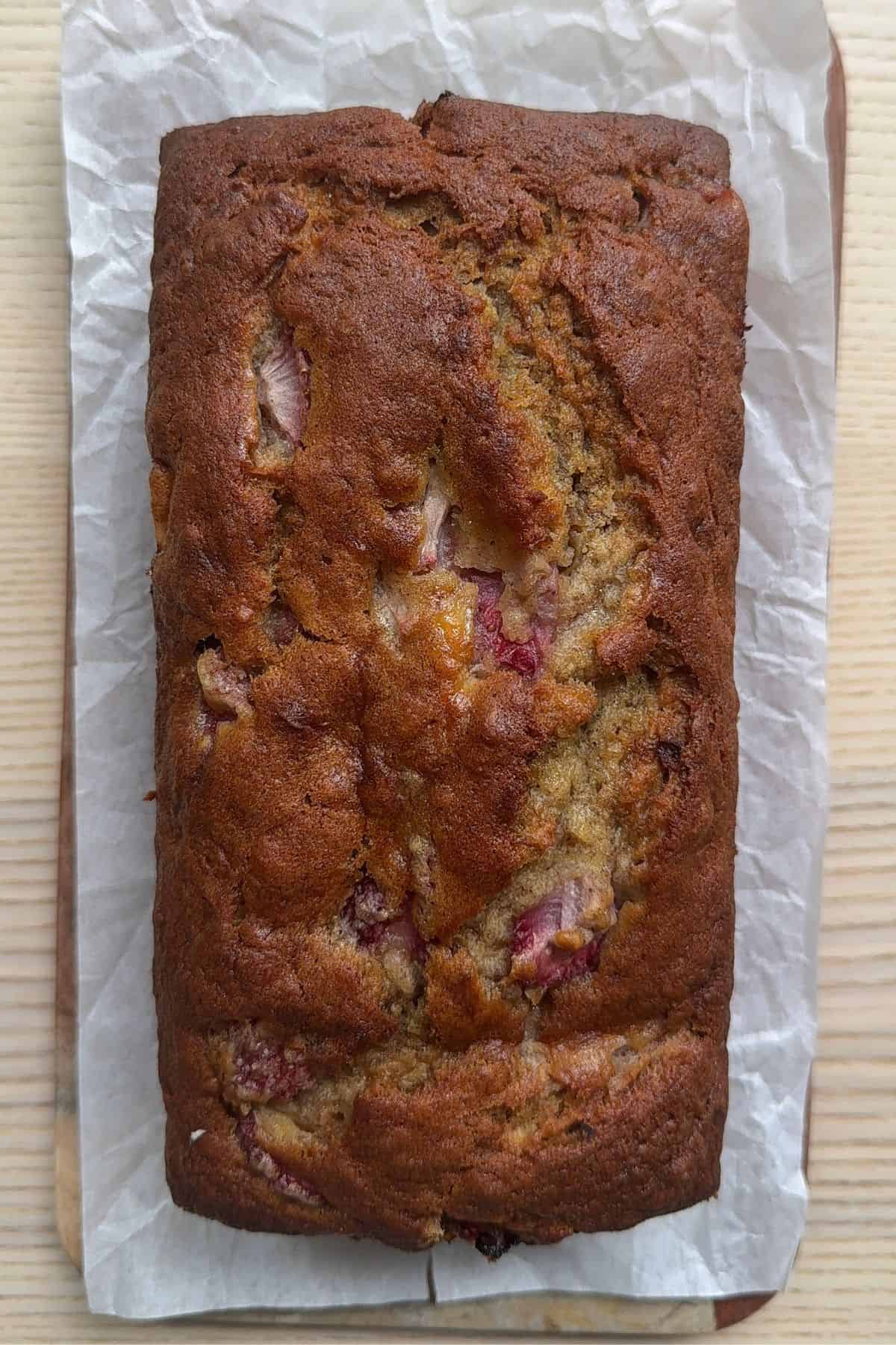 A baked loaf cake on parchment paper.