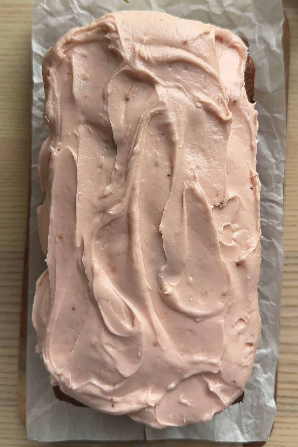 Banana bread frosted with strawberry cream cheese frosting.