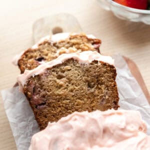 Strawberry banana bread slices with frosting.