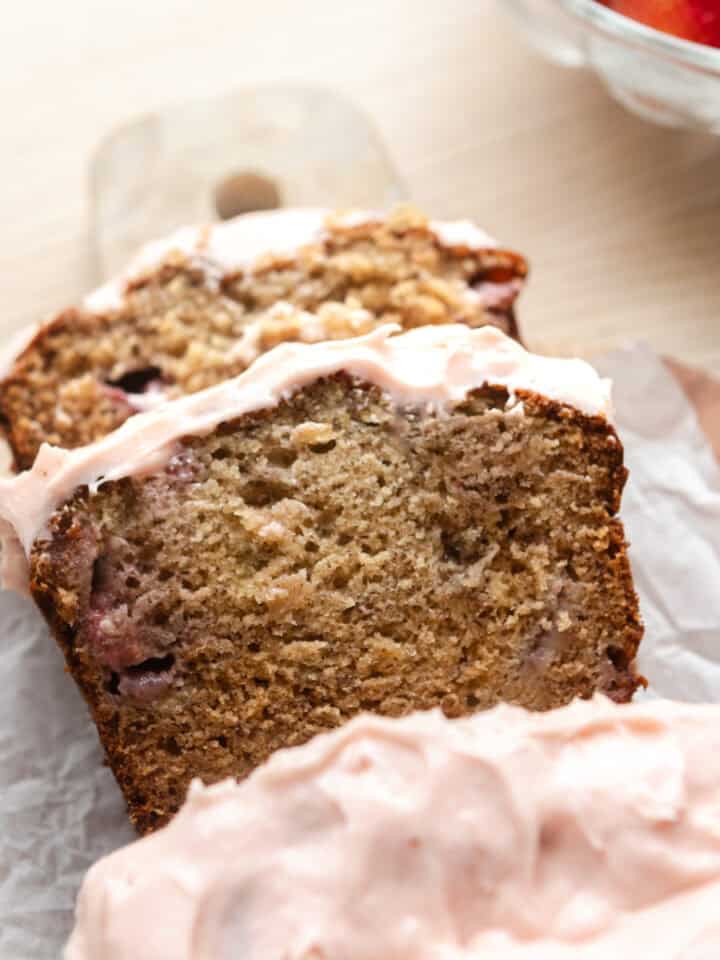 Strawberry banana bread slices with frosting.