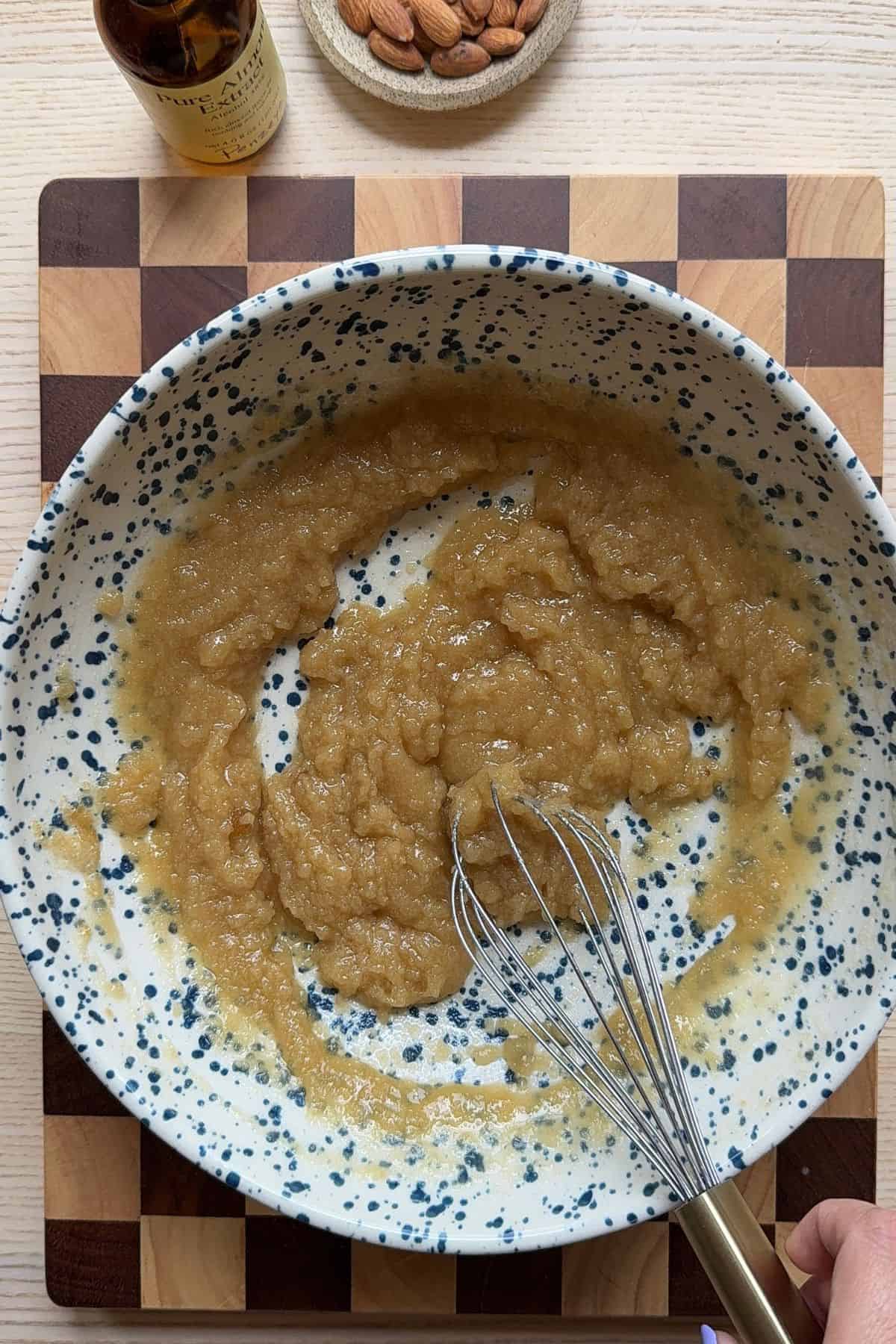 Melted butter and sugar mixed together in a bowl with a whisk.