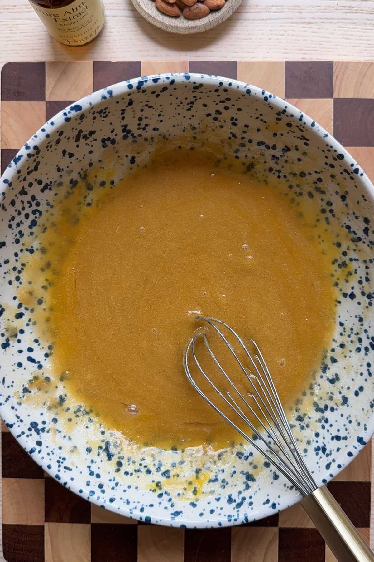 Wet ingredients for blondies in a bowl with a whisk.