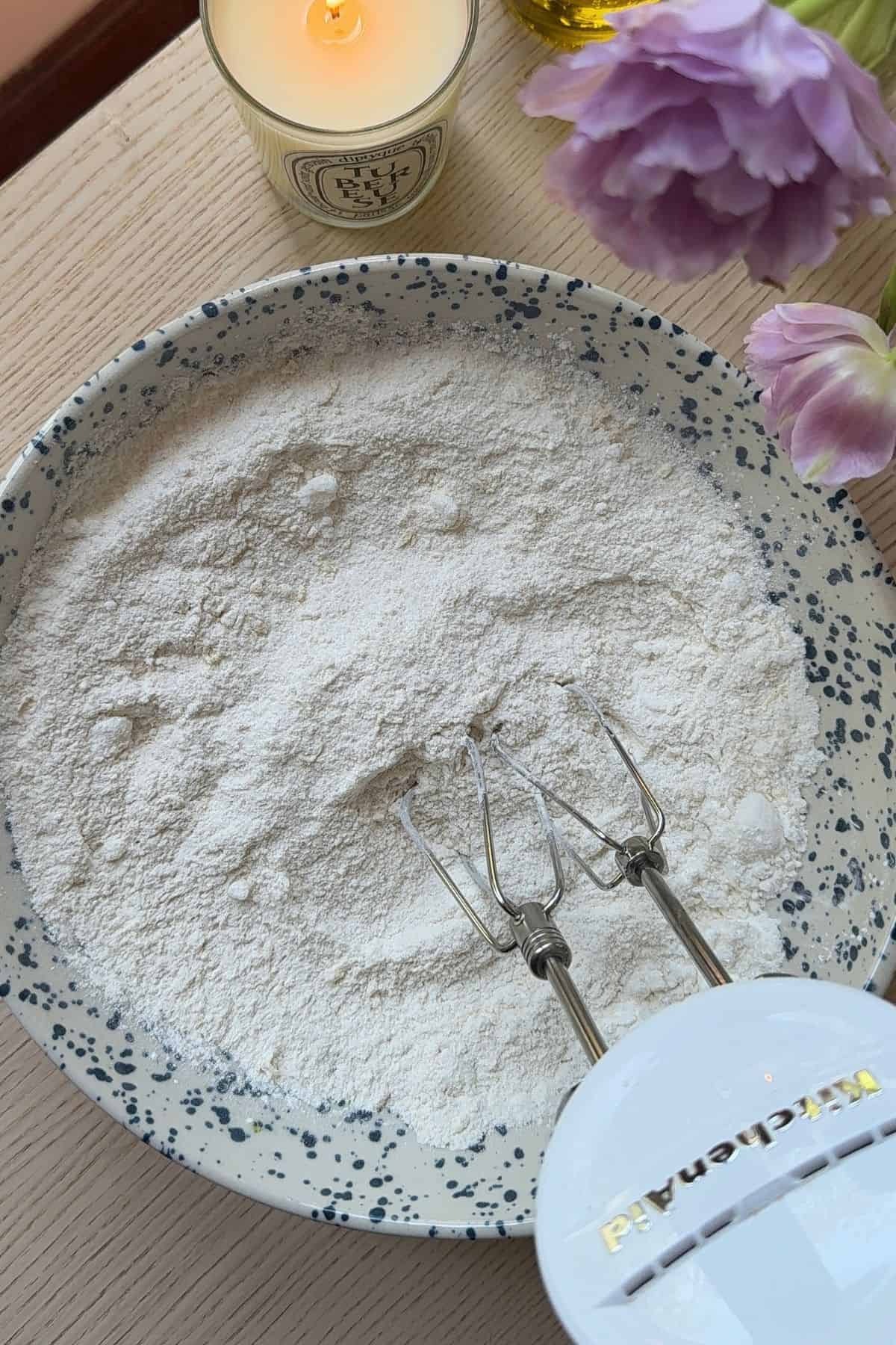 Dry ingredients in a large mixing bowl with a hand mixer.