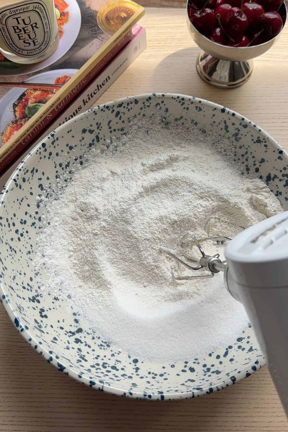 Dry ingredients in a mixing bowl with a hand mixer.