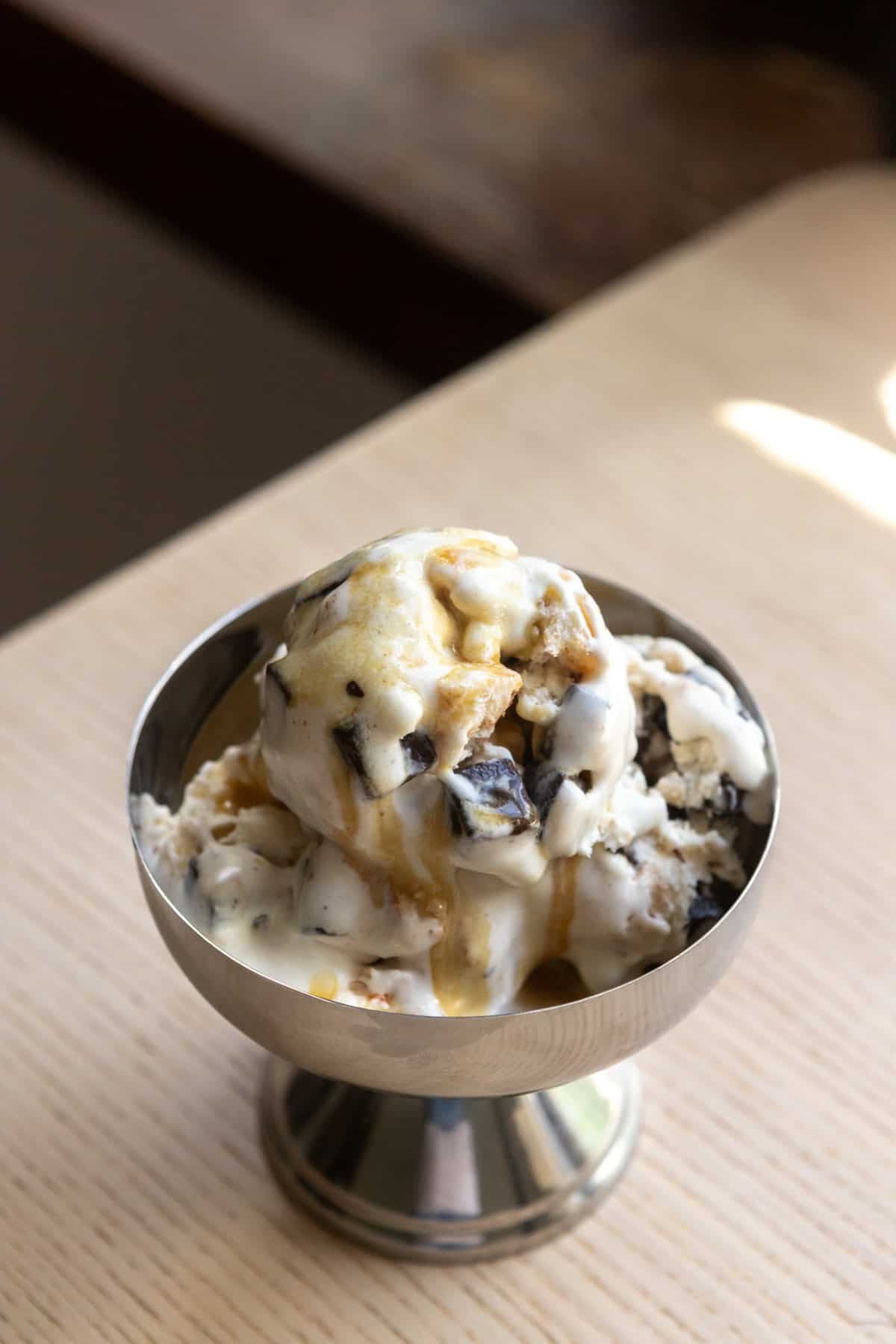 A scoop of chocolate chip pancake ice cream in a steel bowl.
