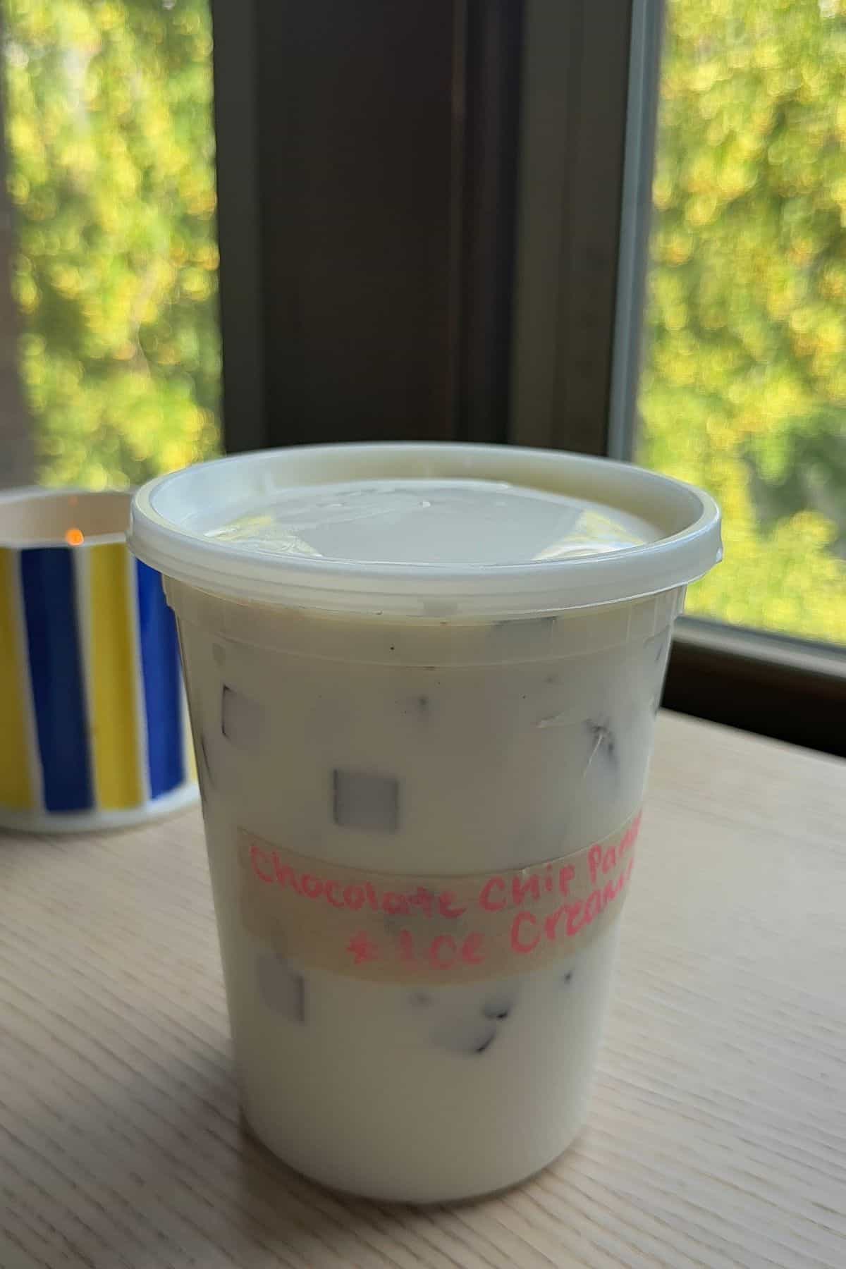 Chocolate chip pancake ice cream in a labelled deli container.