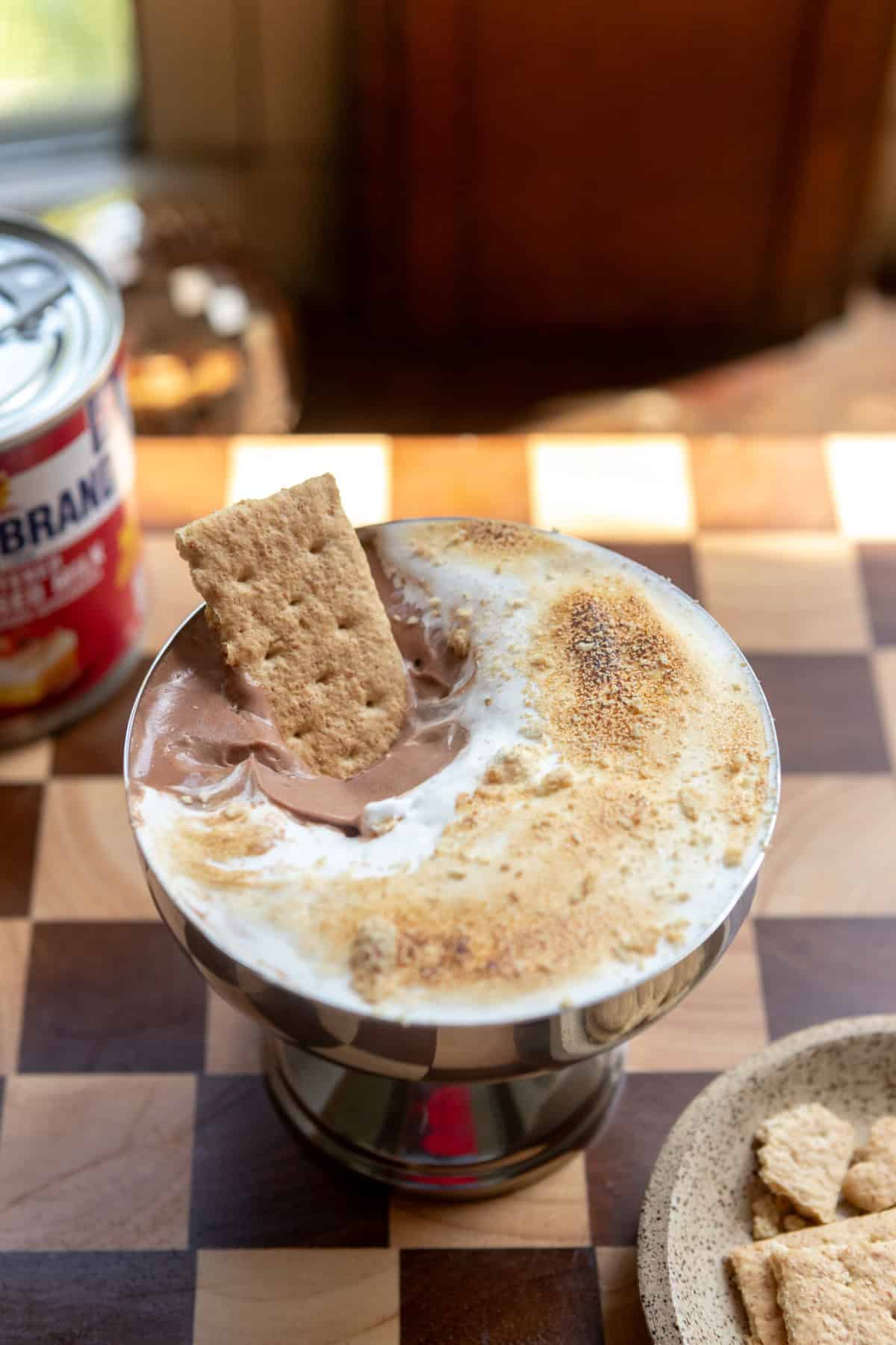 Close up of a s'mores chocolate mousse cup with a graham cracker inside.