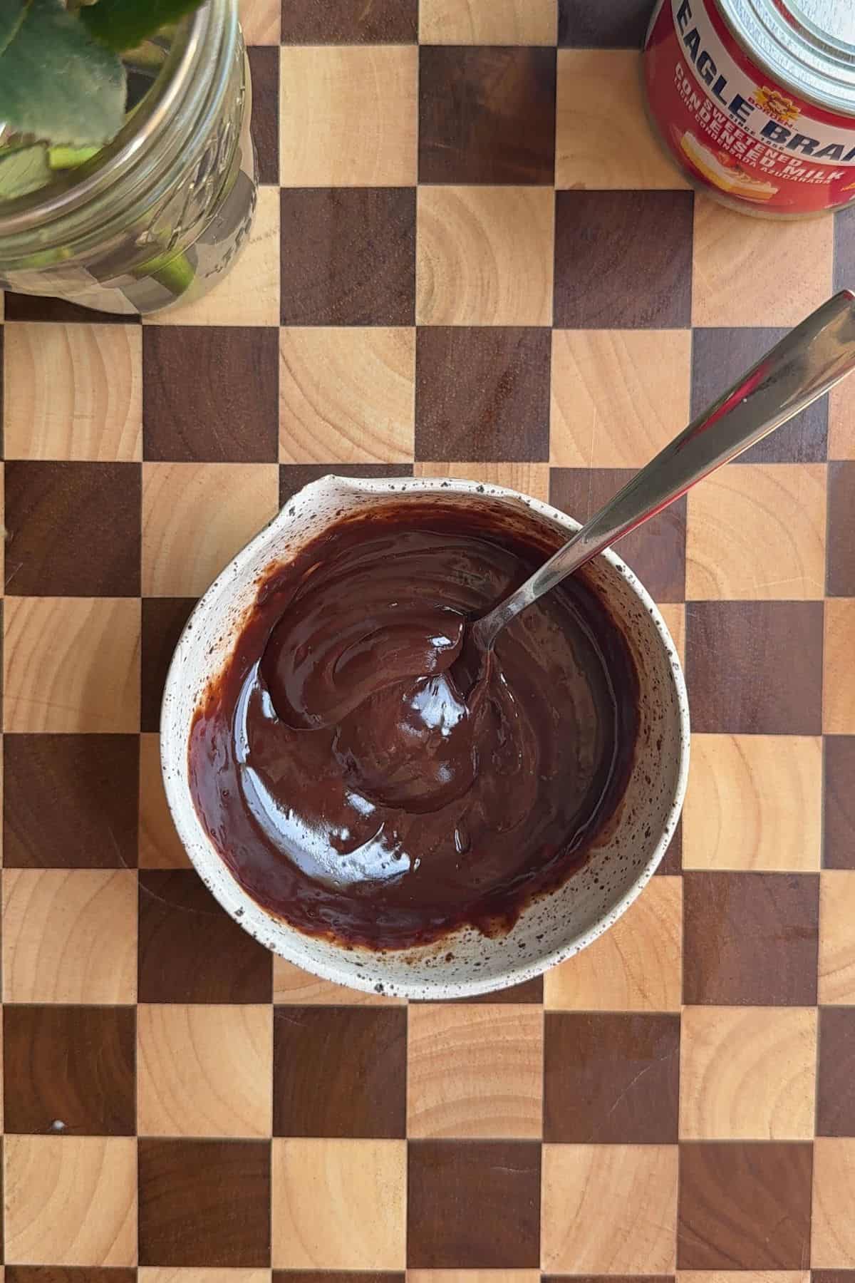 Melted chocolate and heavy cream in a bowl.