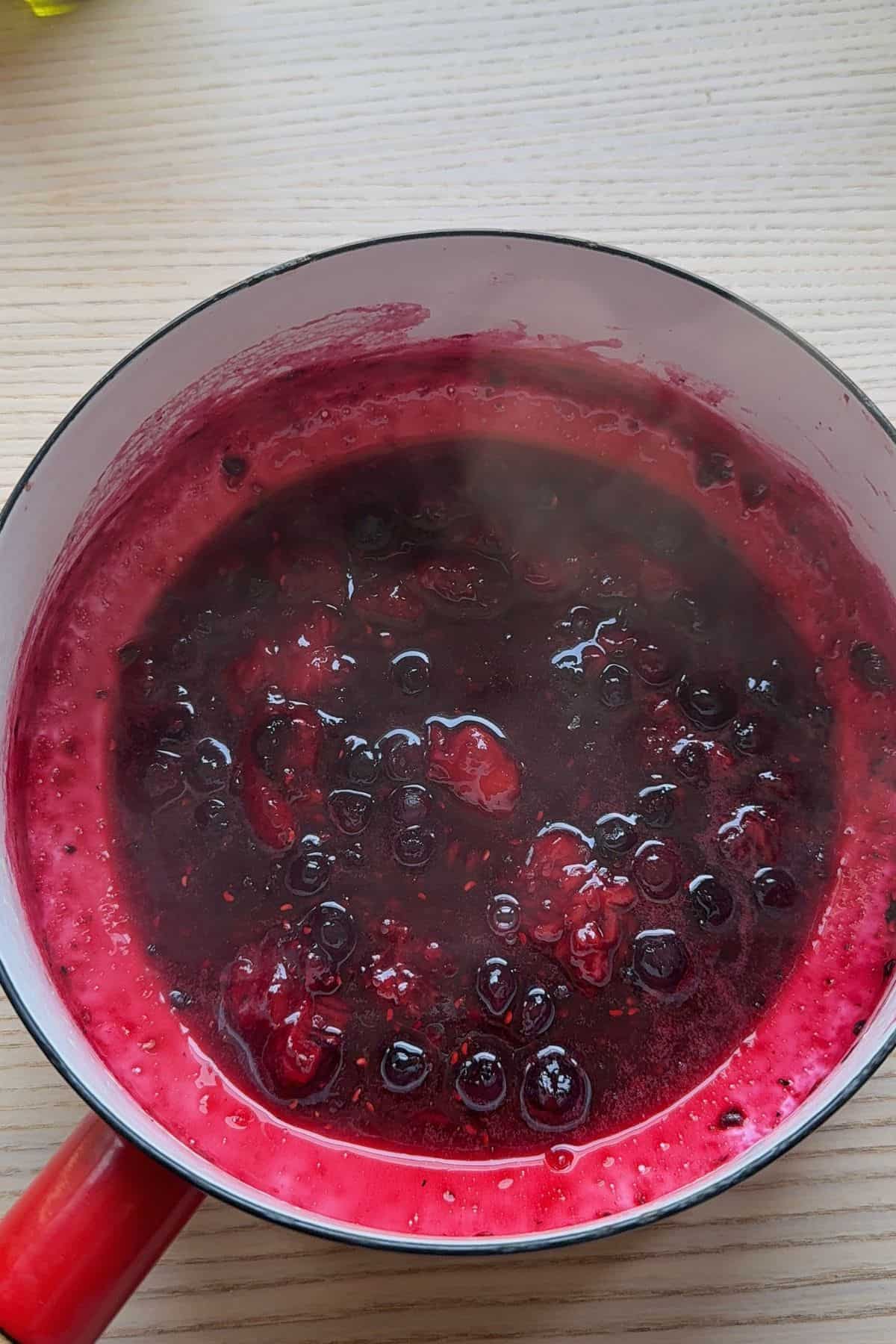Berries cooking down in a saucepan.