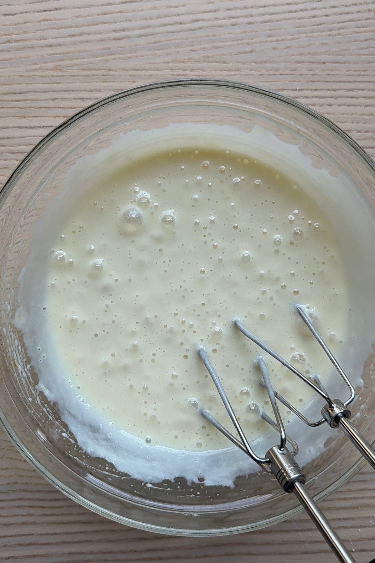 Cream cheese and sweetened condensed milk mixed together in a bowl.